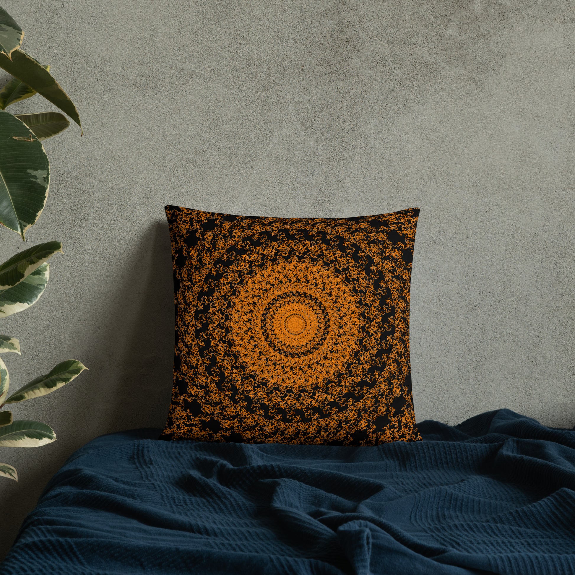 18″×18″ throw pillow with the 'The Sun' orange and black geometric design on a bed.