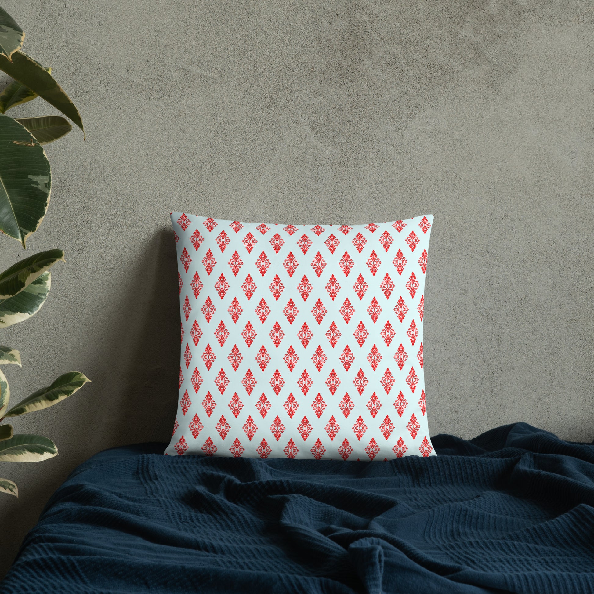 18″×18″ throw pillow with the 'Digon' sky blue and red geometric pattern on a bed.