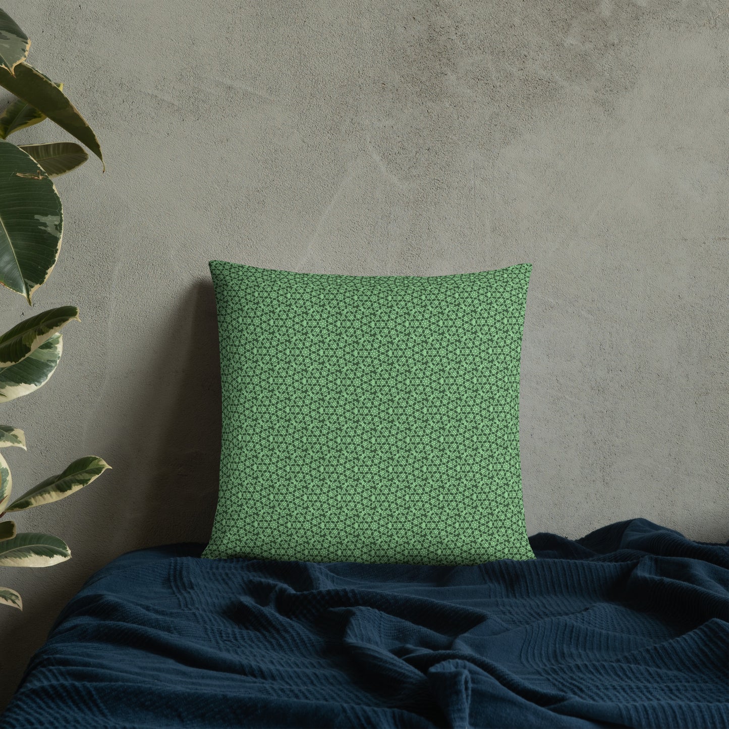 18″×18″ throw pillow with the 'Heptagon' green geometric pattern on a bed.