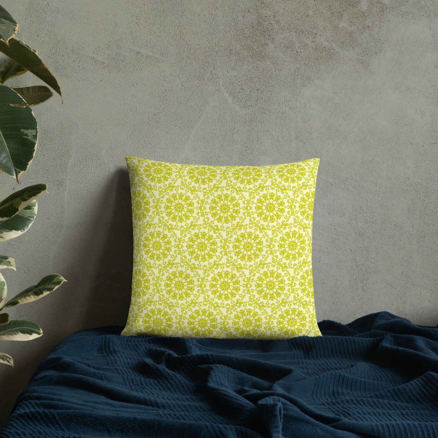 18″×18″ throw pillow with the 'Hendecagon' yellow-green geometric pattern on a bed with concrete wall