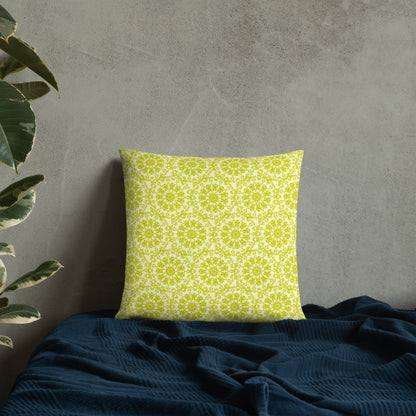18″×18″ throw pillow with the 'Hendecagon' yellow-green geometric pattern on a bed with concrete wall