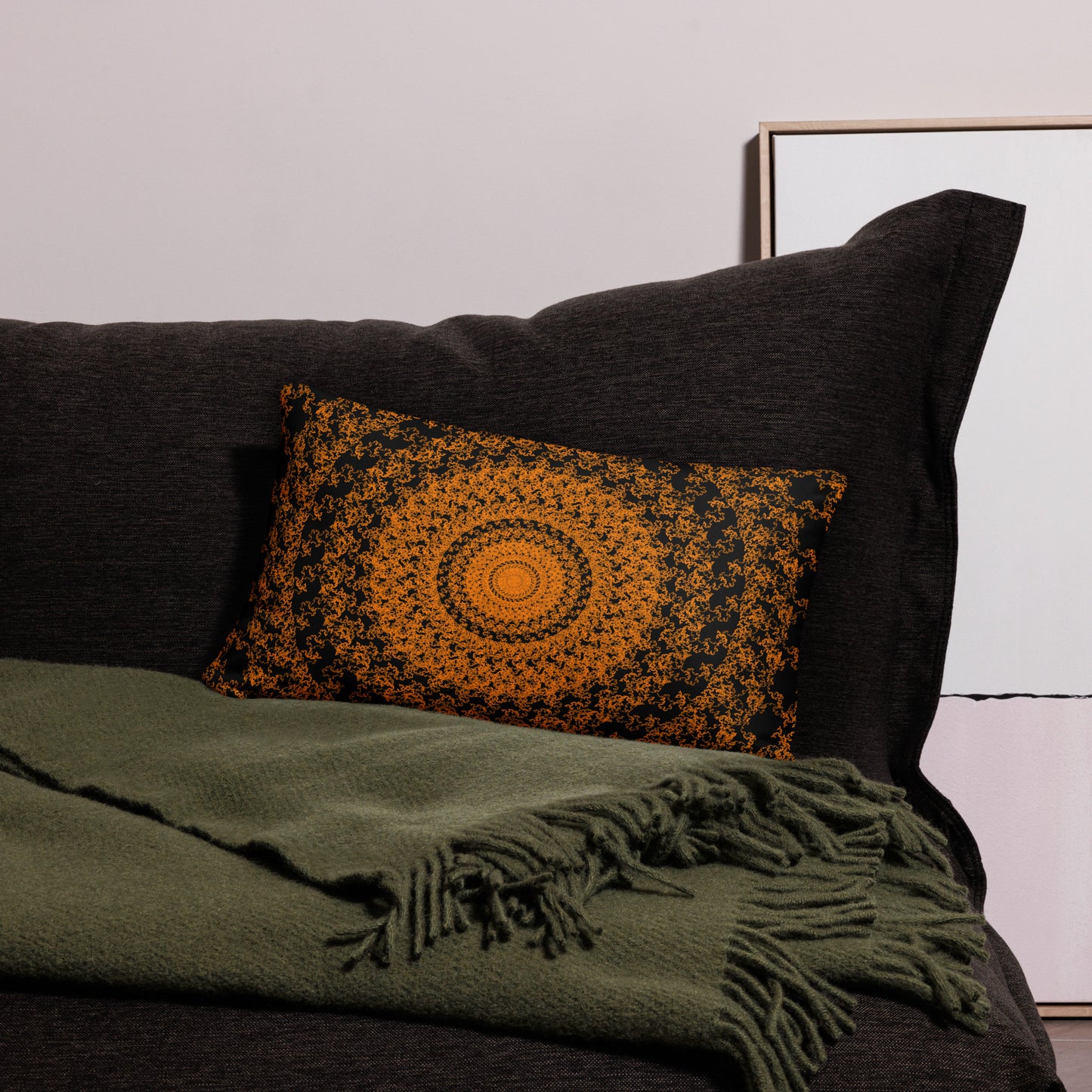 20″×12″ throw pillow with the 'The Sun' orange and black geometric design on a couch.