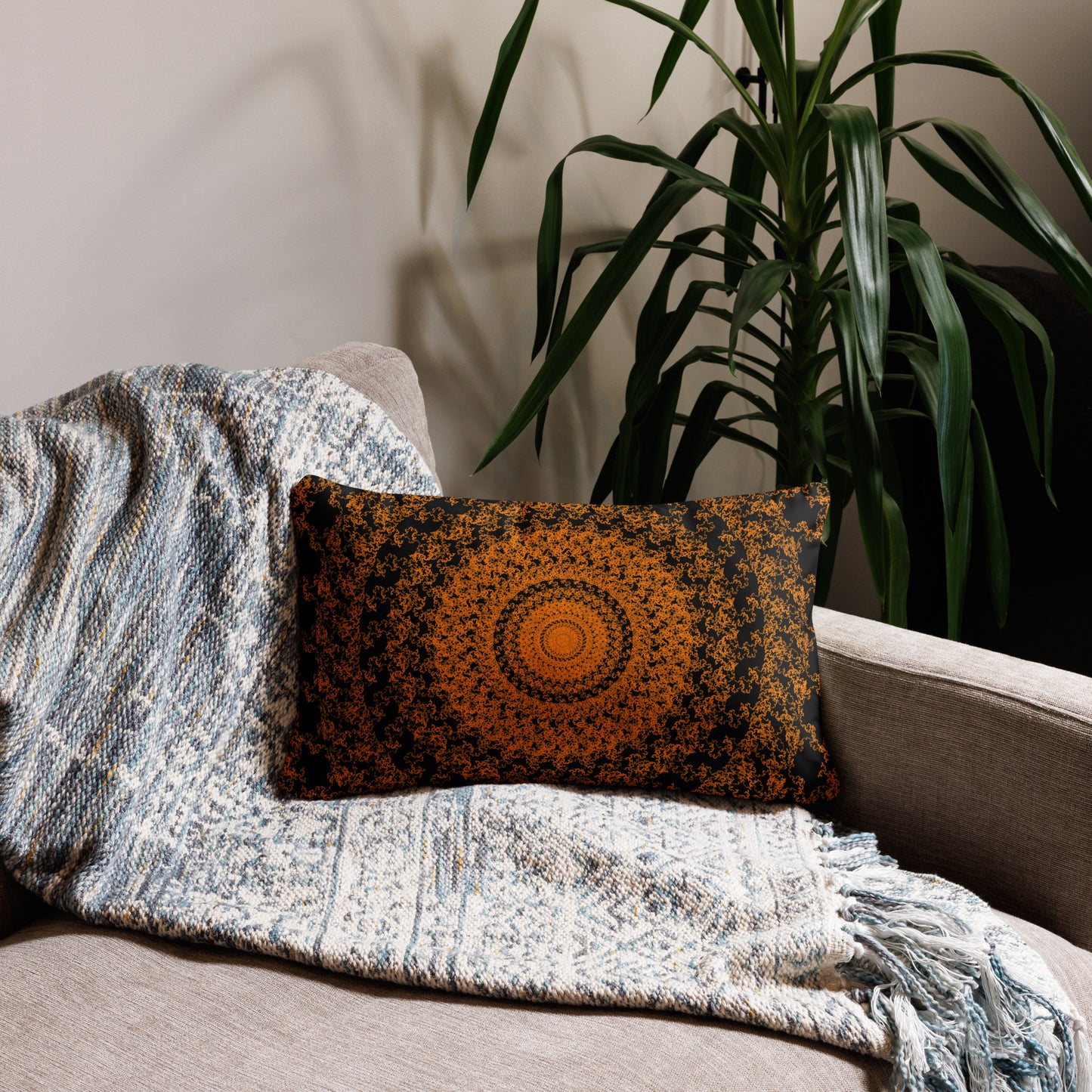 20″×12″ throw pillow with the 'The Sun' orange and black geometric design on a couch.