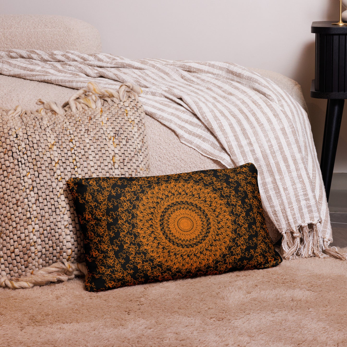20″×12″ throw pillow with the 'The Sun' orange and black geometric design on a couch.