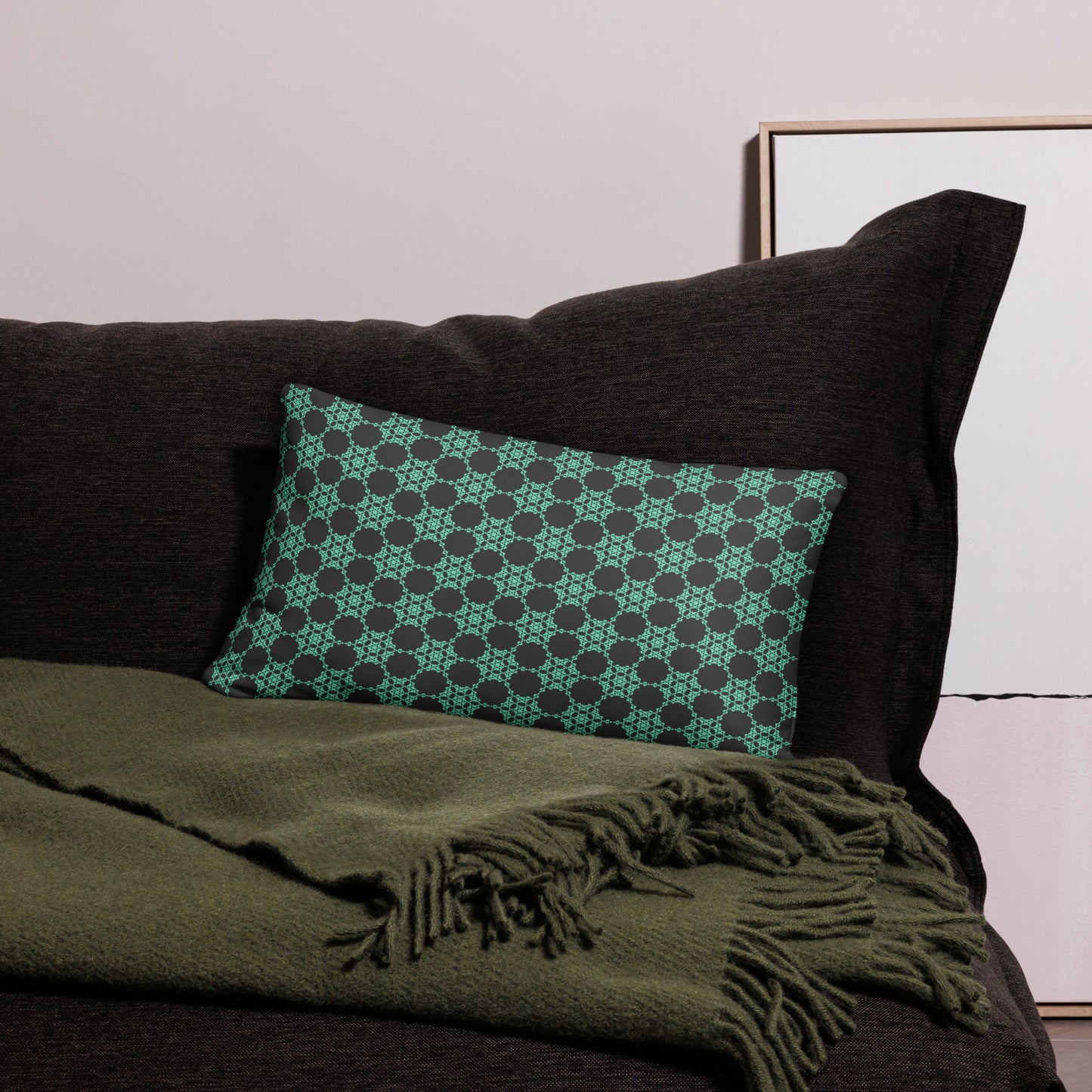 20″×12″ throw pillow with the 'Flowers Victory' charcoal and mint geometric pattern on a couch.