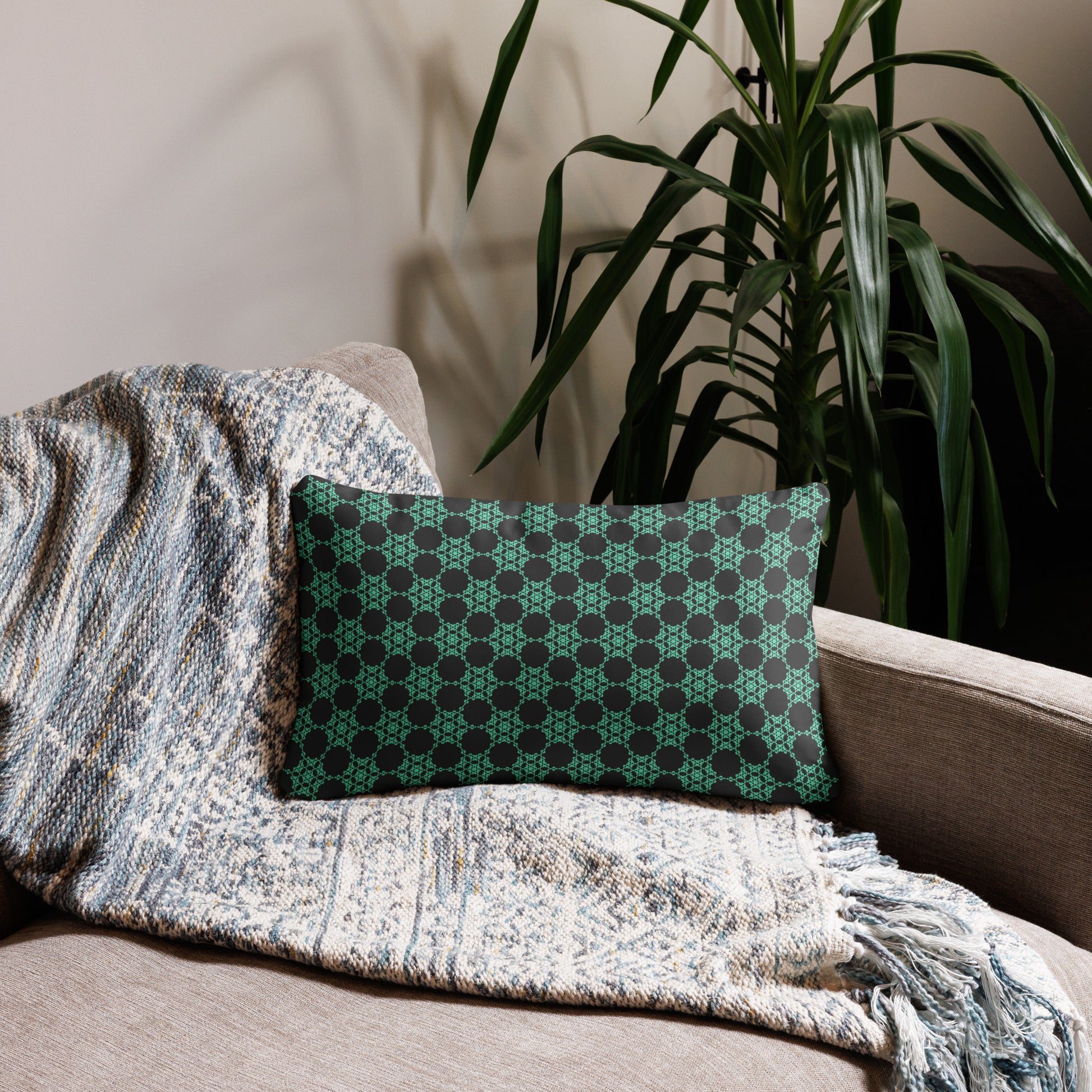 20″×12″ throw pillow with the 'Flowers Victory' charcoal and mint geometric pattern on a couch.