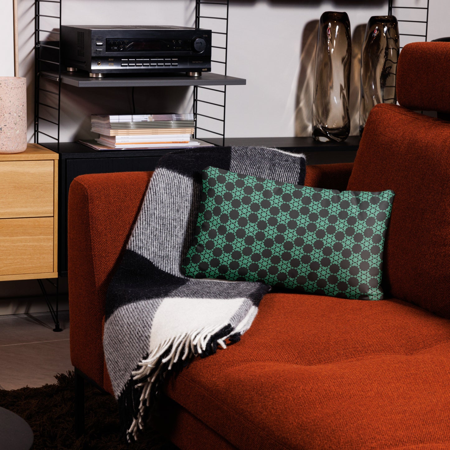 20″×12″ throw pillow with the 'Flowers Victory' charcoal and mint geometric pattern on a couch.