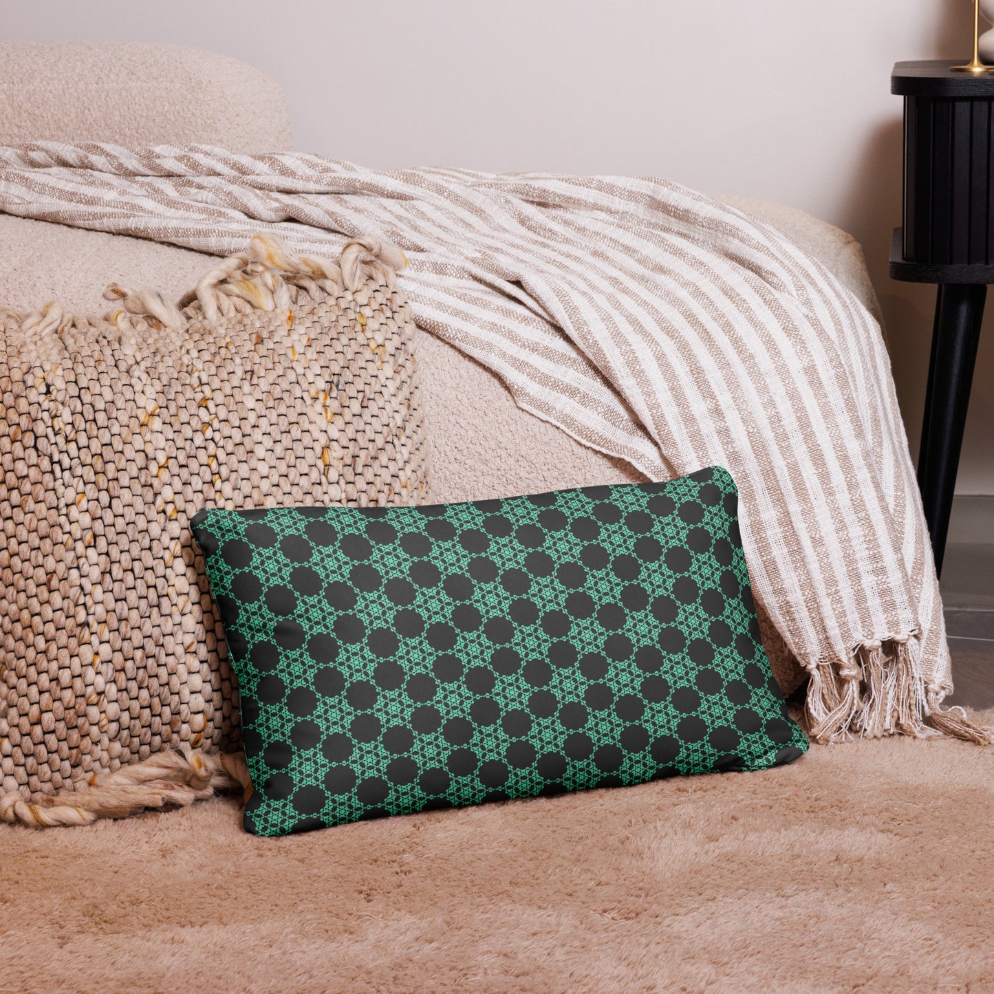 20″×12″ throw pillow with the 'Flowers Victory' charcoal and mint geometric pattern on a couch.