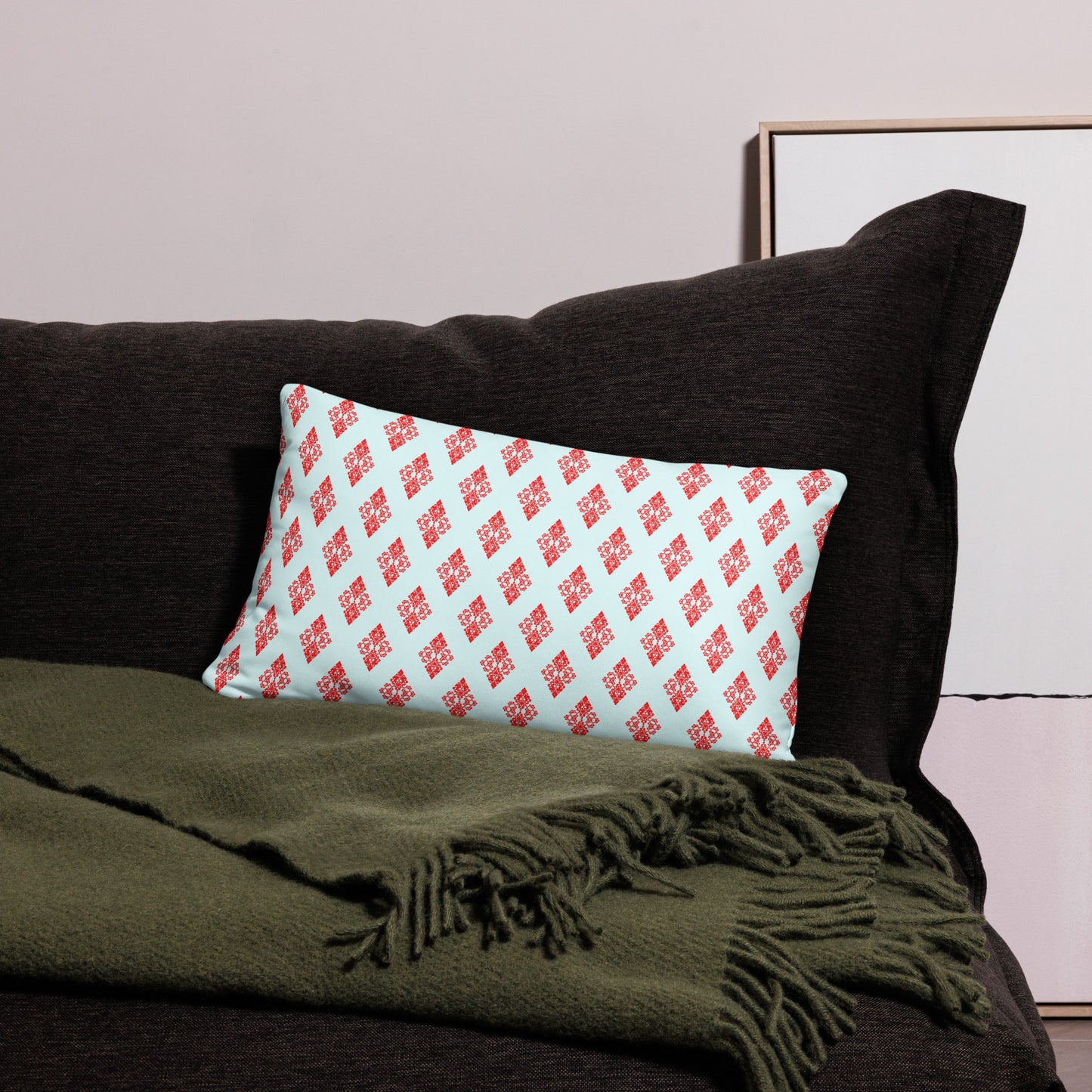 20″×12″ throw pillow with the 'Digon' sky blue and red geometric pattern on a couch.