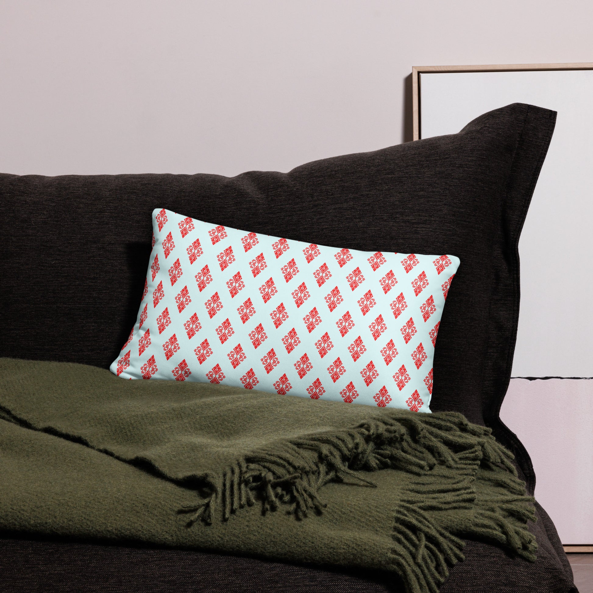 20″×12″ throw pillow with the 'Digon' sky blue and red geometric pattern on a couch.