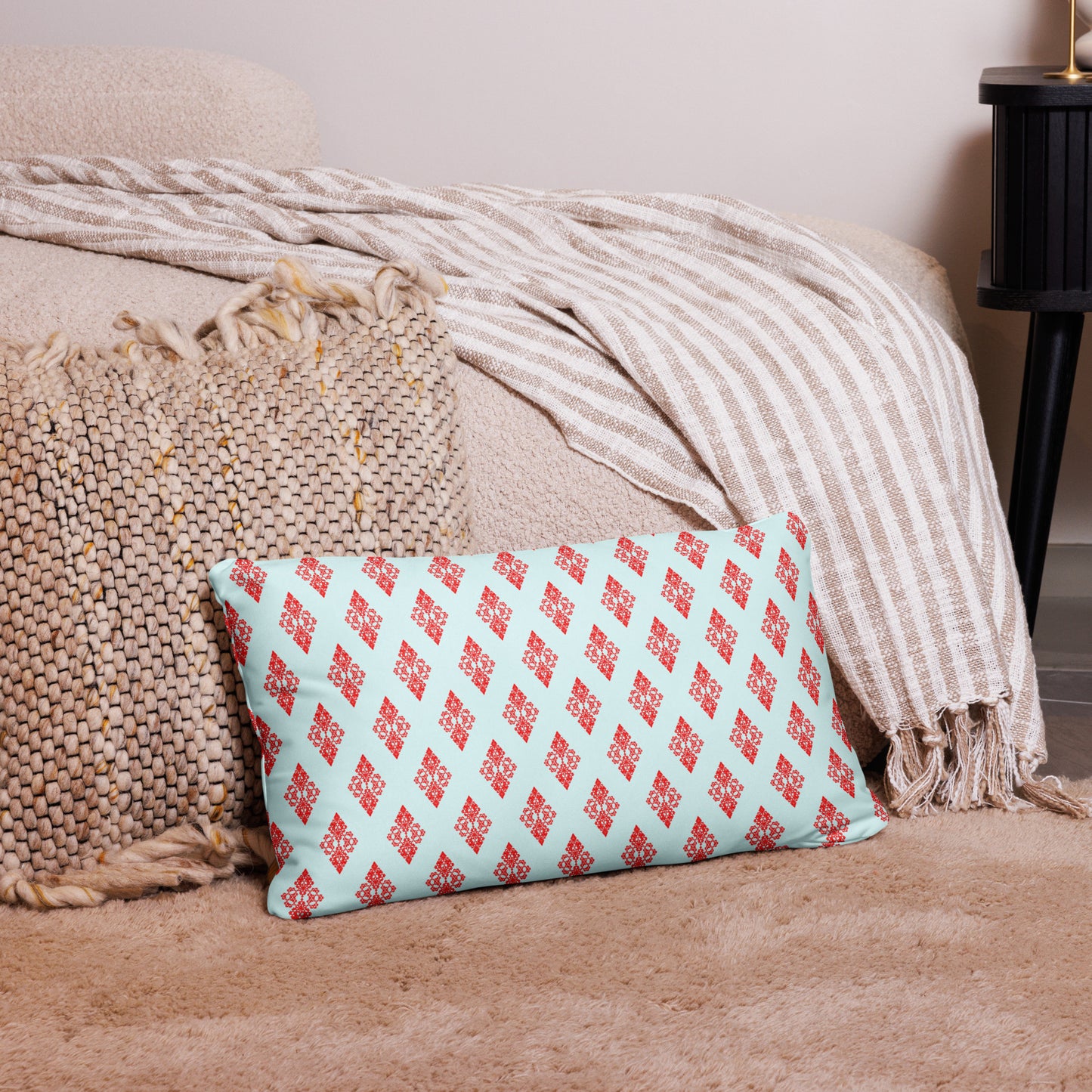 20″×12″ throw pillow with the 'Digon' sky blue and red geometric pattern on a couch.