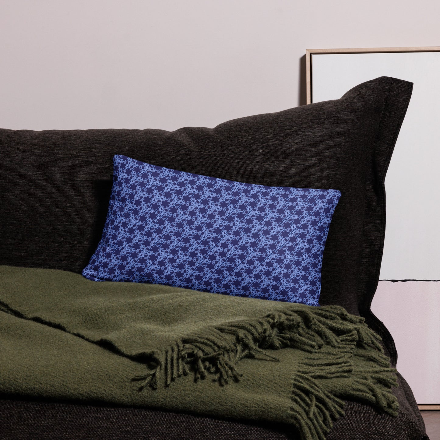 20″×12″ throw pillow with the 'Trigon' navy and blue geometric pattern on a couch.