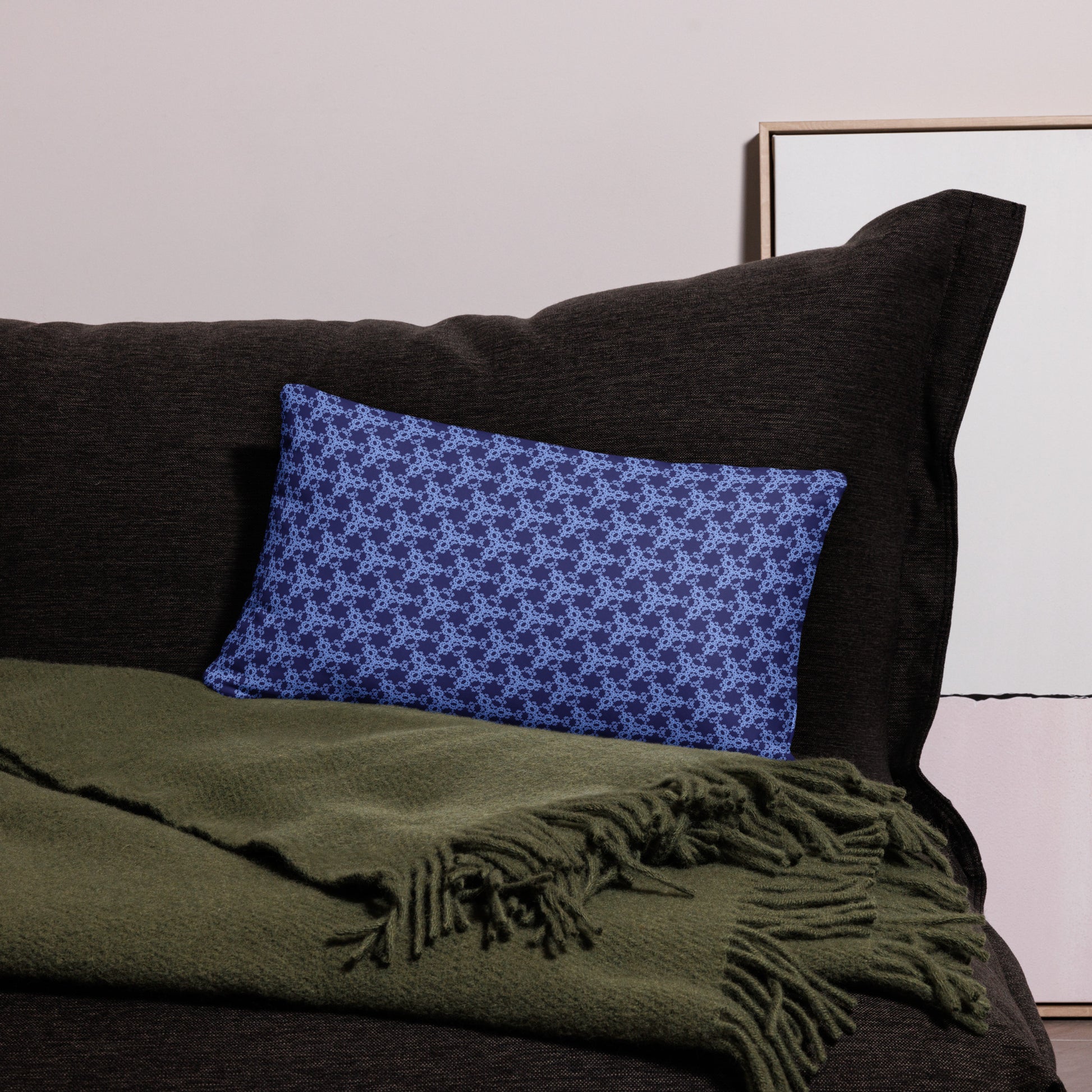 20″×12″ throw pillow with the 'Trigon' navy and blue geometric pattern on a couch.