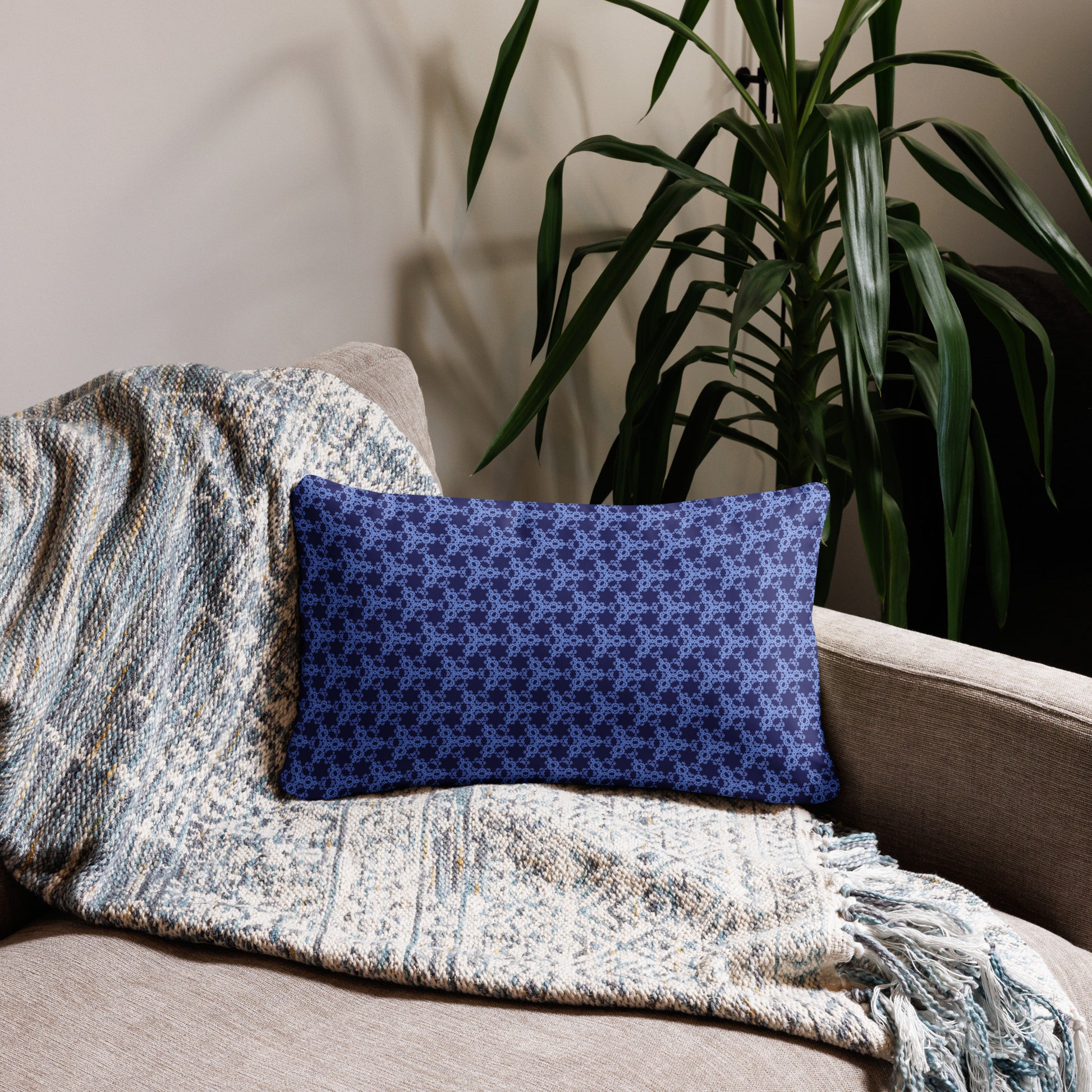 20″×12″ throw pillow with the 'Trigon' navy and blue geometric pattern on a couch.