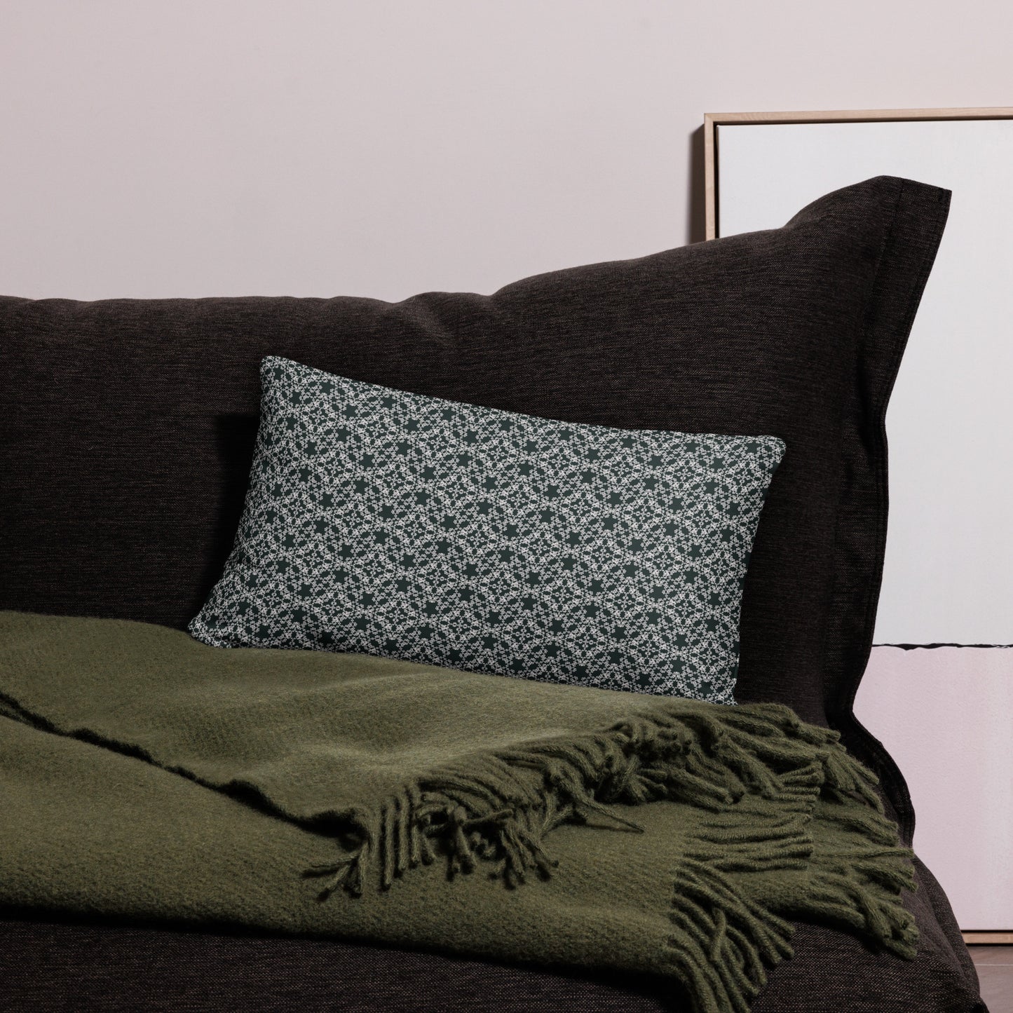 20″×12″ throw pillow with the 'Tetragon' charcoal and white geometric pattern on a couch.