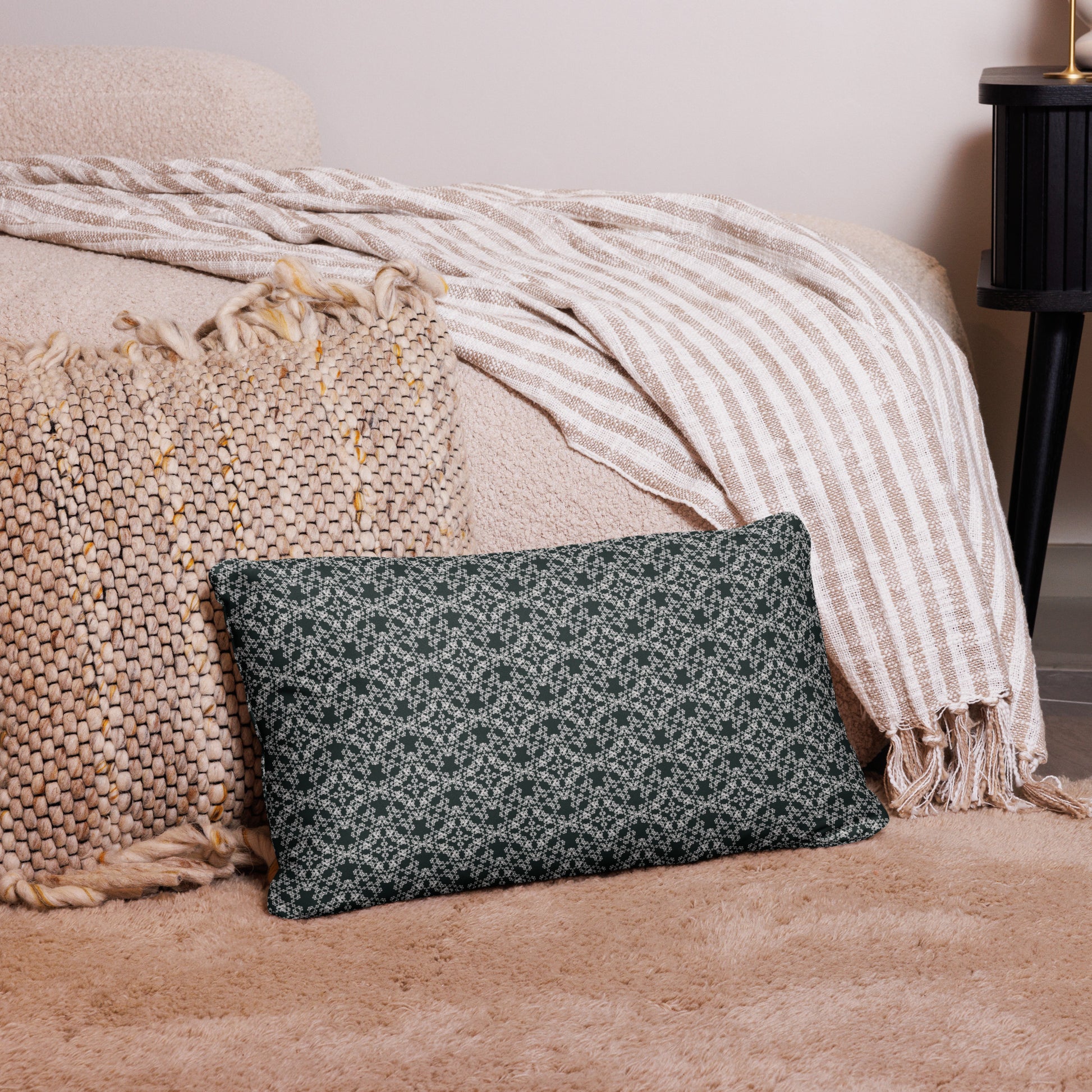 20″×12″ throw pillow with the 'Tetragon' charcoal and white geometric pattern on a couch.