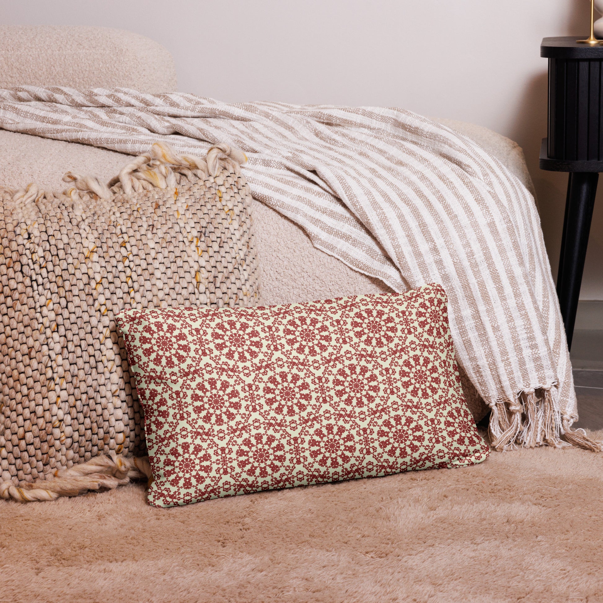 20″×12″ throw pillow with the ‘Decagon’ terracotta and beige geometric pattern on a bedroom floor with striped linen throws.