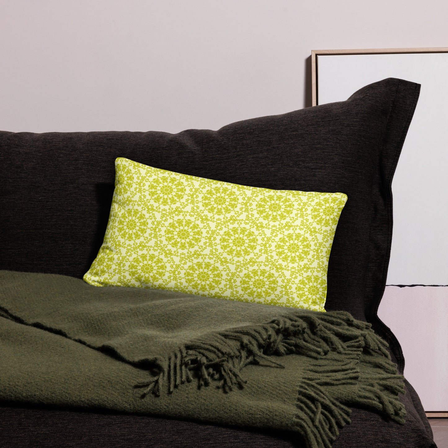 20″×12″ throw pillow with the 'Hendecagon' yellow-green geometric pattern on a dark sofa with green throw