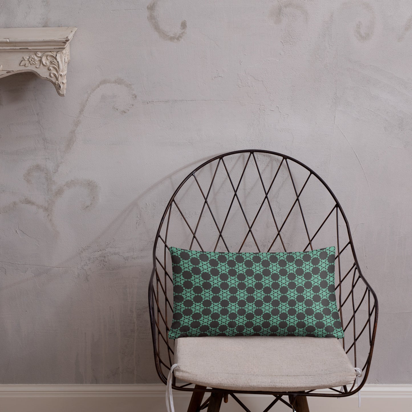 20″×12″ throw pillow with the 'Flowers Victory' charcoal and mint geometric pattern on a chair.