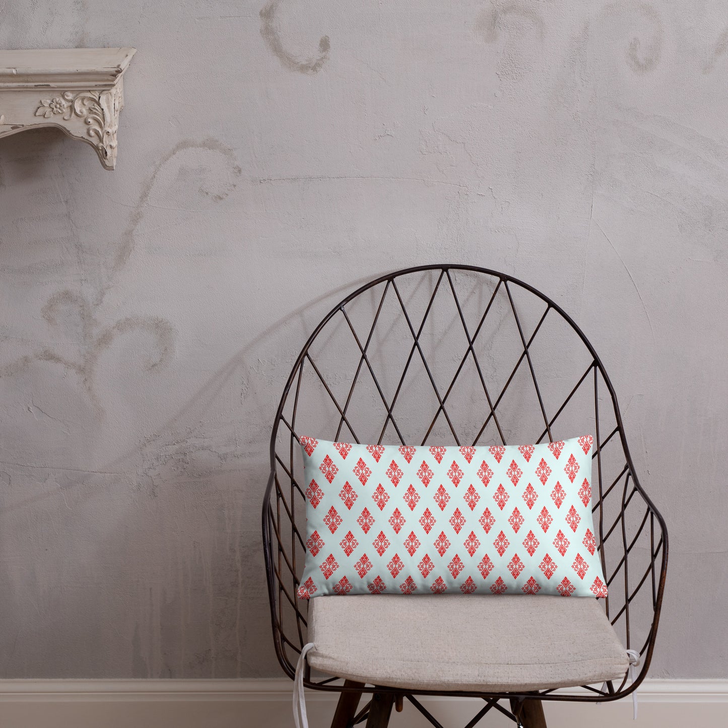 20″×12″ throw pillow with the 'Digon' sky blue and red geometric pattern on a chair.
