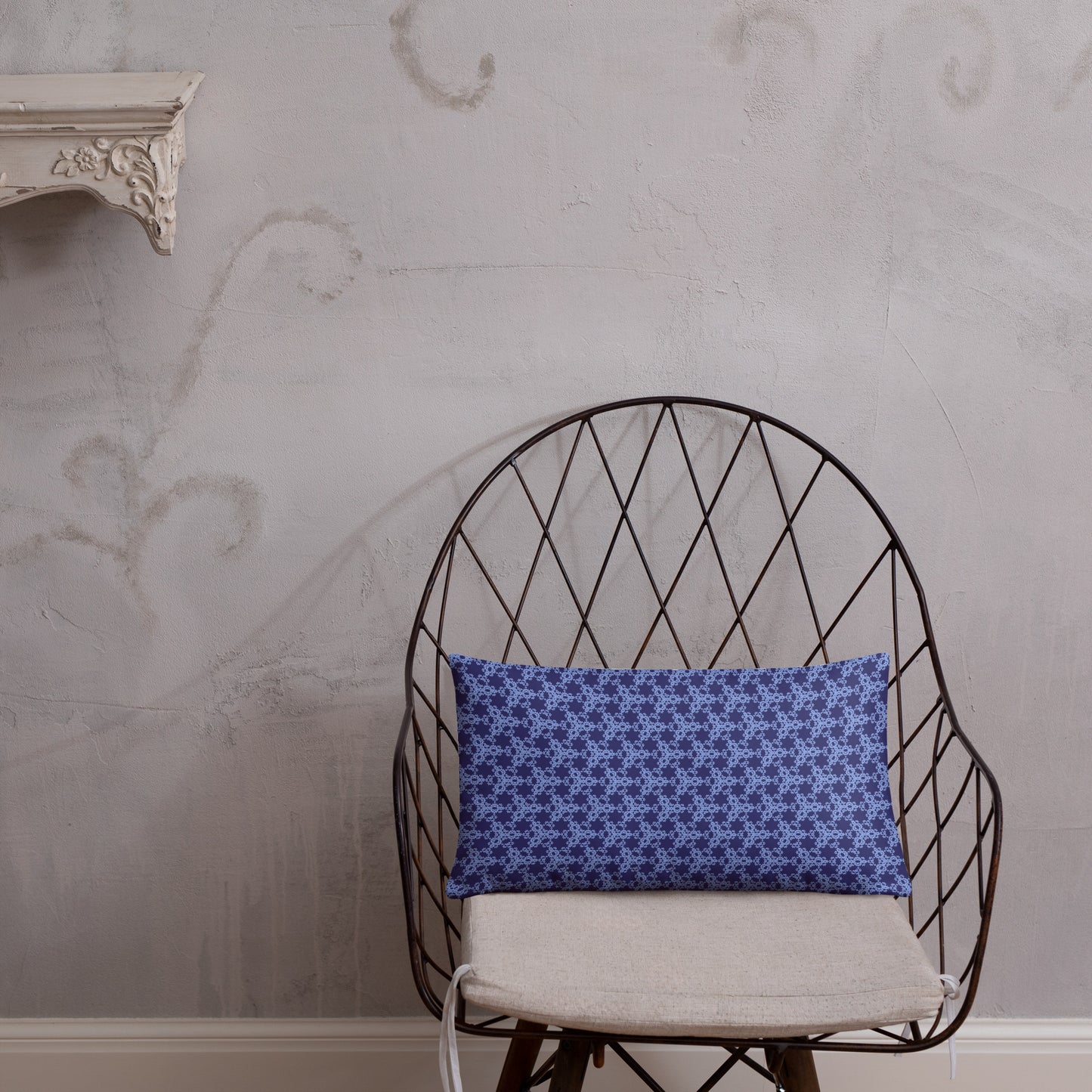 20″×12″ throw pillow with the 'Trigon' navy and blue geometric pattern on a chair.