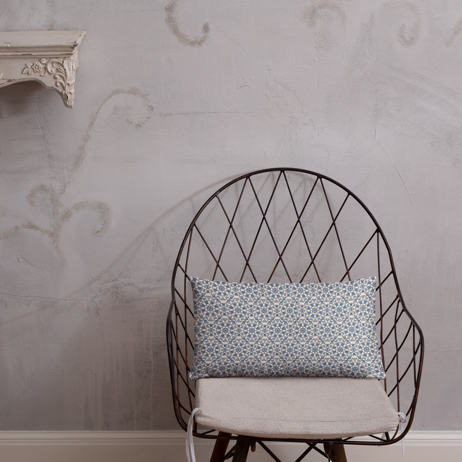 20″×12″ throw pillow with the ‘Octagon’ navy and beige geometric pattern on a wire chair.