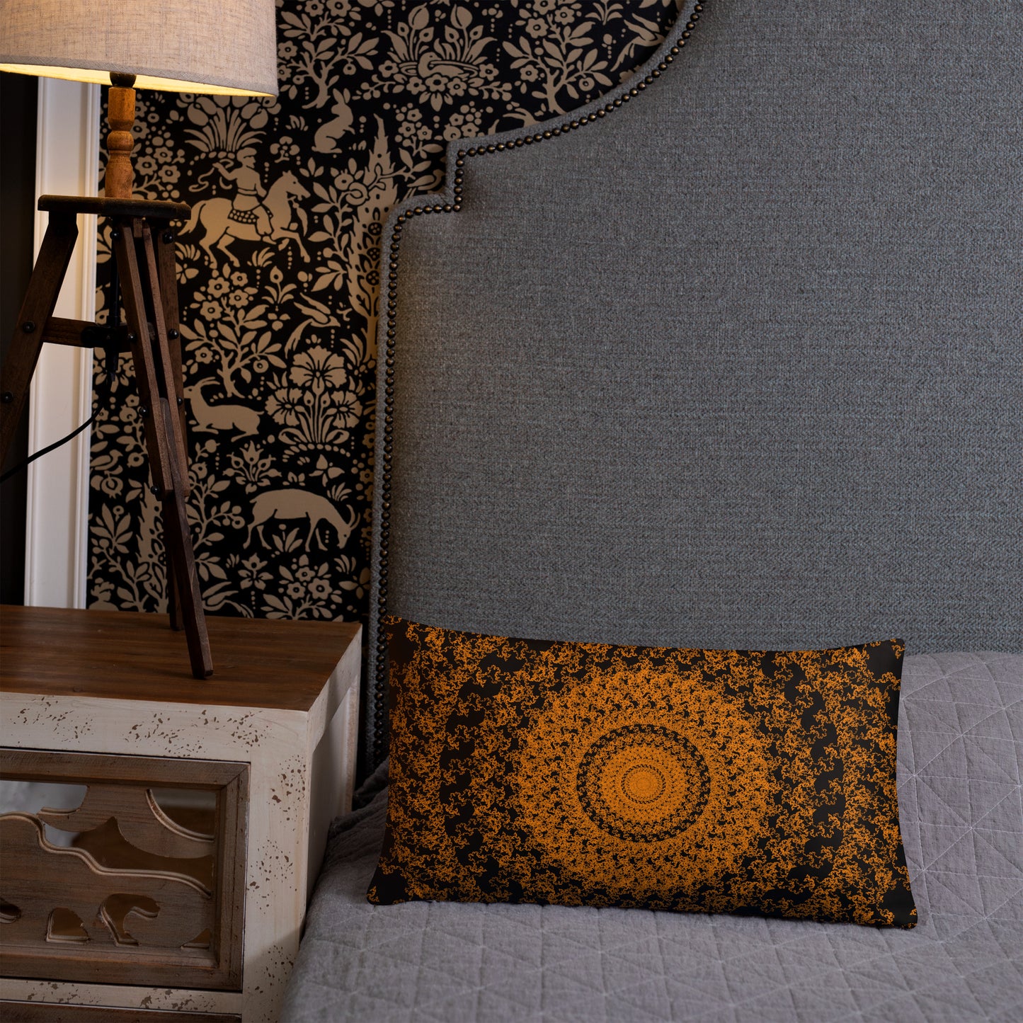 20″×12″ throw pillow with the 'The Sun' orange and black geometric design on a bed.