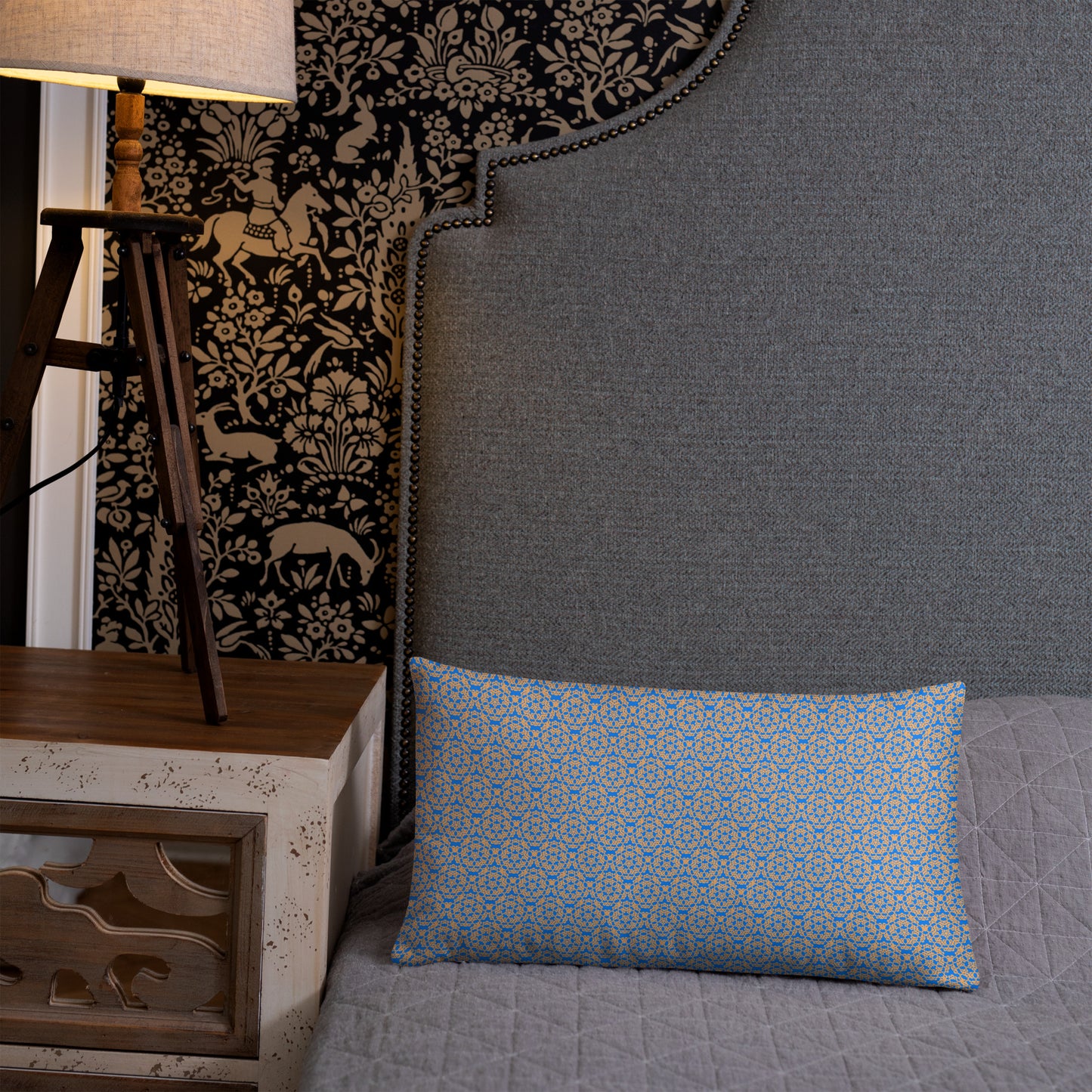 20″×12″ throw pillow with the 'Pentagon' blue and yellow geometric pattern on a bed.