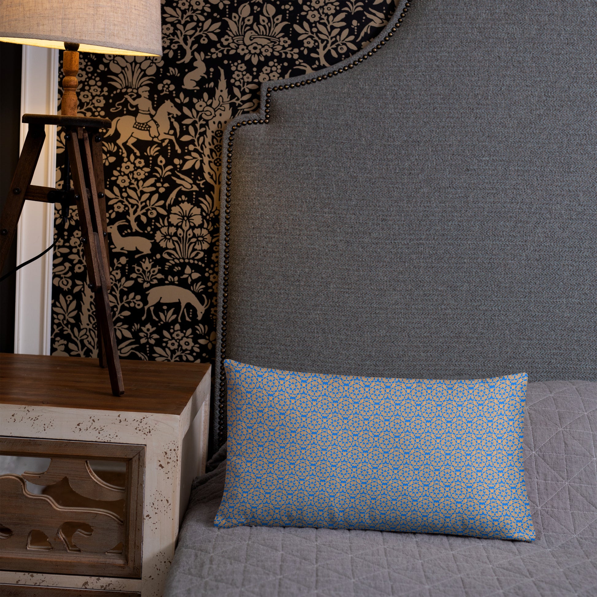 20″×12″ throw pillow with the 'Pentagon' blue and yellow geometric pattern on a bed.