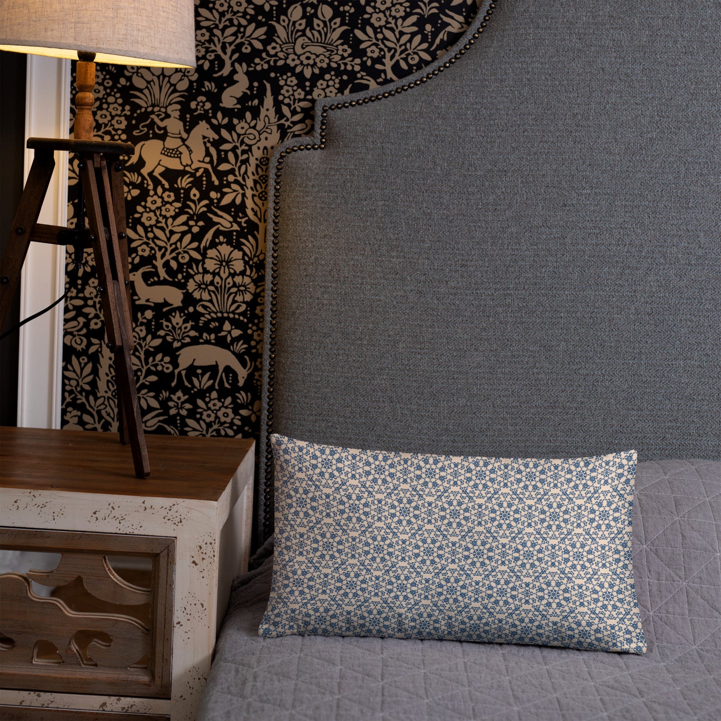 20″×12″ throw pillow with the ‘Octagon’ navy and beige geometric pattern on a bed with upholstered headboard.