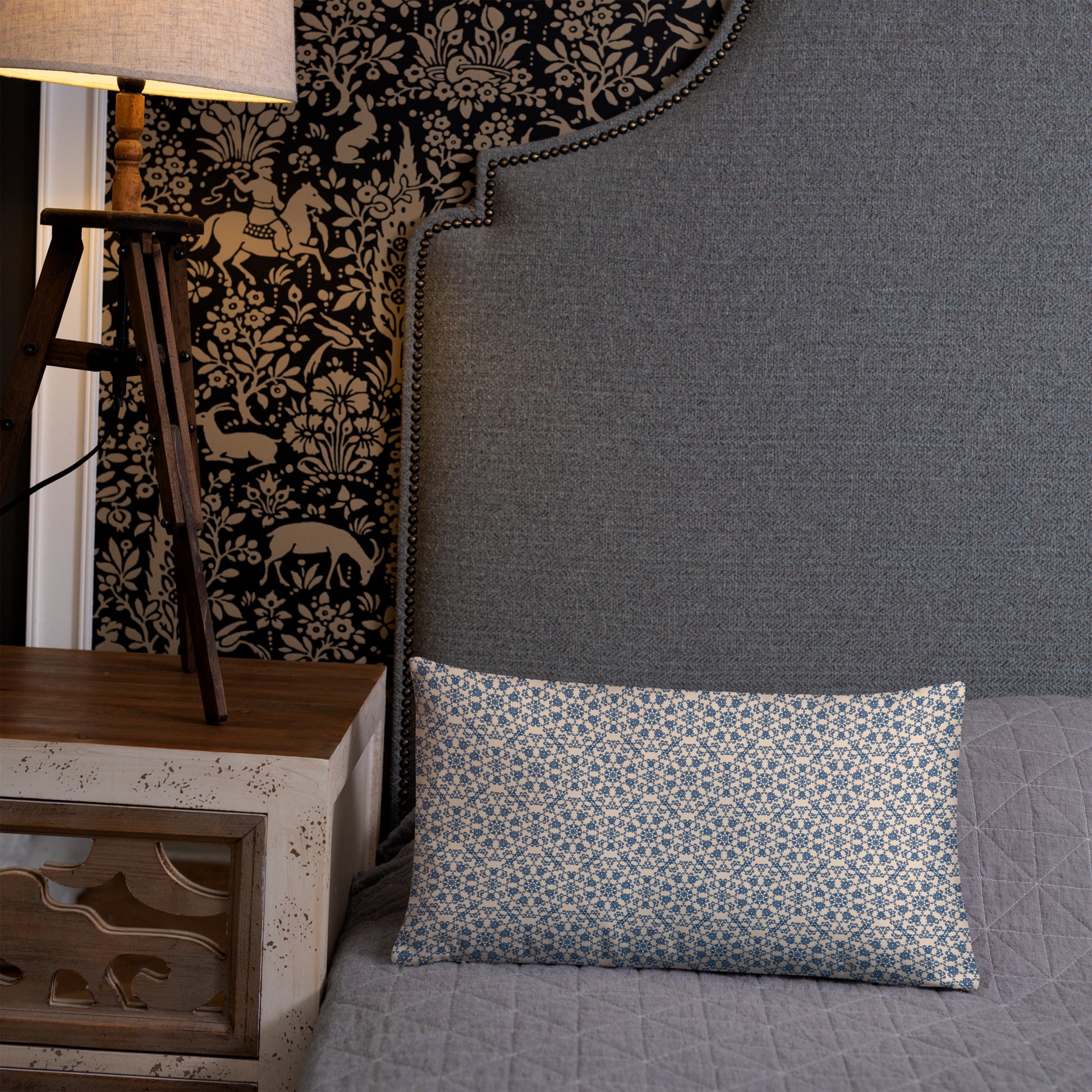 20″×12″ throw pillow with the ‘Octagon’ navy and beige geometric pattern on a bed with upholstered headboard.