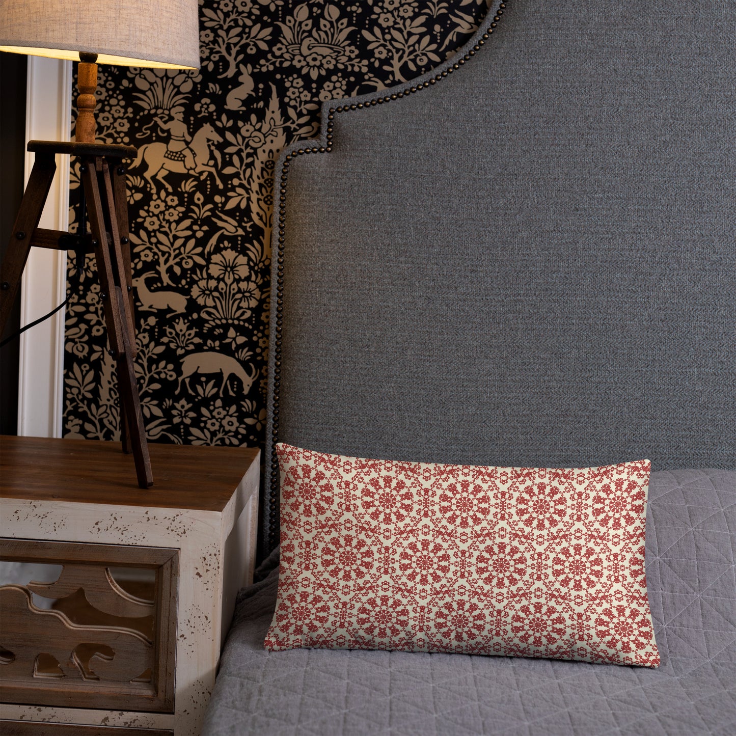 20″×12″ throw pillow with the ‘Decagon’ terracotta and beige geometric pattern on a grey bed with an ornate headboard.