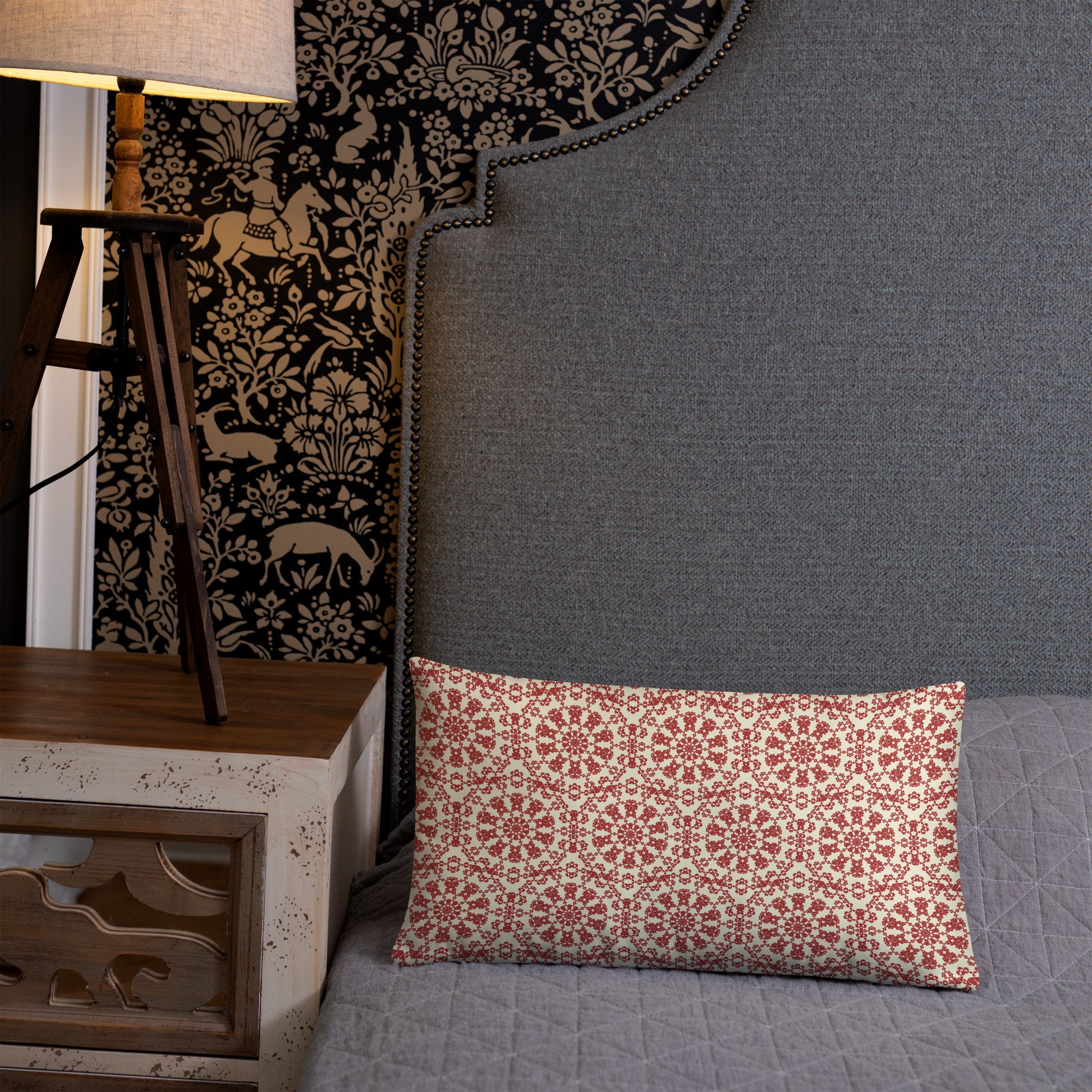 20″×12″ throw pillow with the ‘Decagon’ terracotta and beige geometric pattern on a grey bed with an ornate headboard.