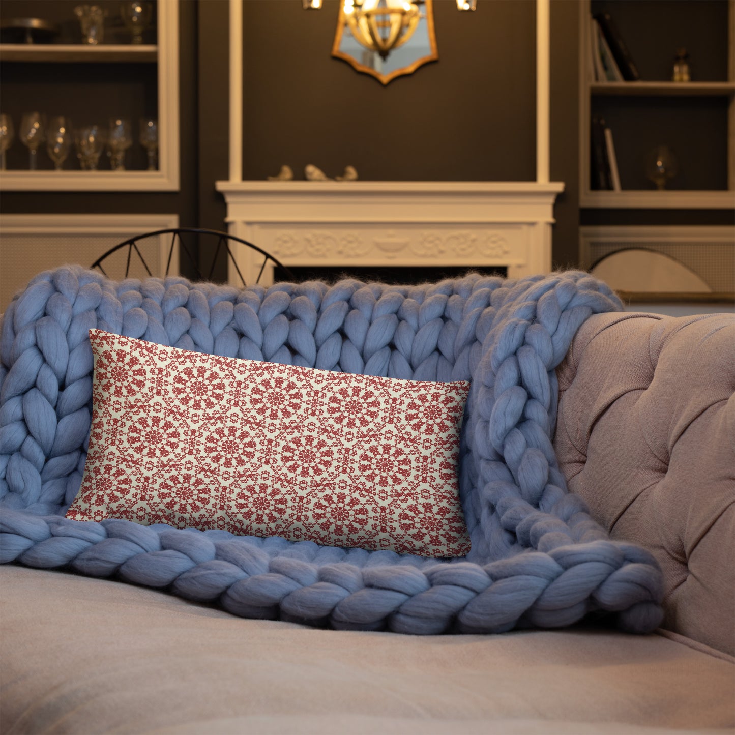 20″×12″ throw pillow with the ‘Decagon’ terracotta and beige geometric pattern on a blue sofa with a chunky knit blanket.