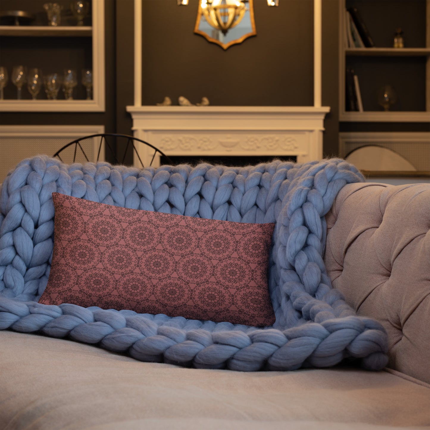 20″×12″ throw pillow with the 'Dodecagon' rose geometric pattern on tufted sofa with chunky blue knit blanket.
