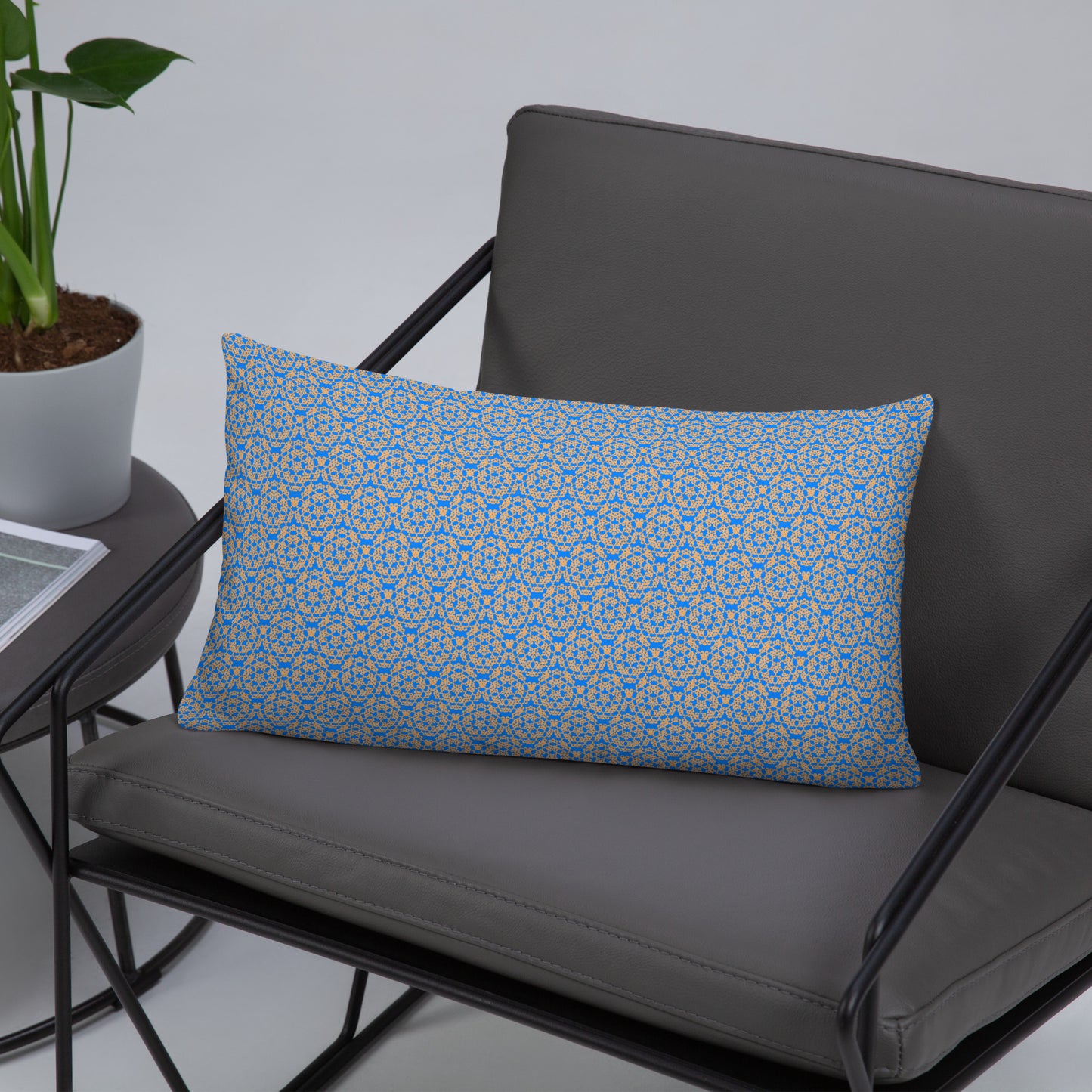 Front of the 20″×12″ basic pillow with the 'Pentagon' blue and yellow fractal geometric pattern on a chair.