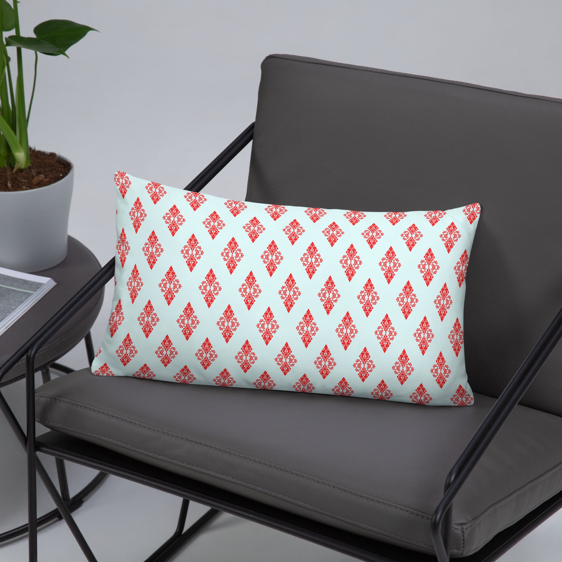 20″×12″ throw pillow with the 'Digon' sky blue and red geometric pattern on a chair.
