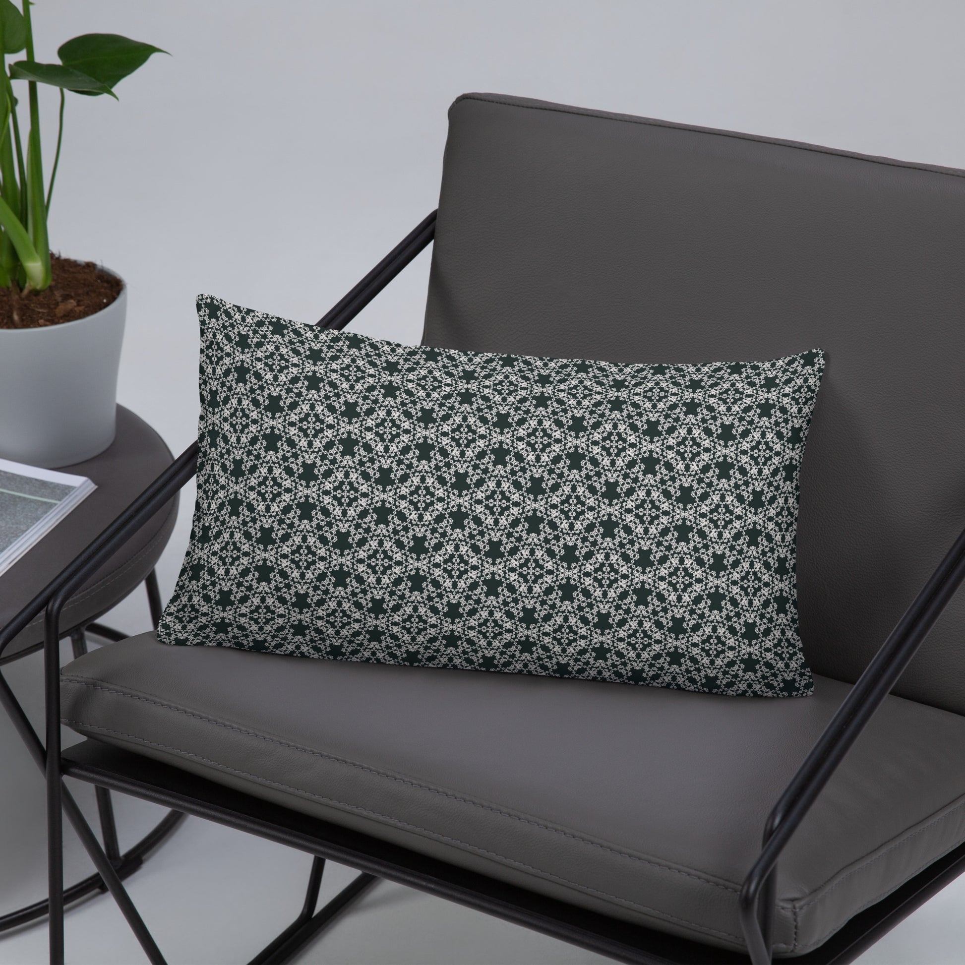 20″×12″ throw pillow with the 'Tetragon' charcoal and white geometric pattern on a chair.