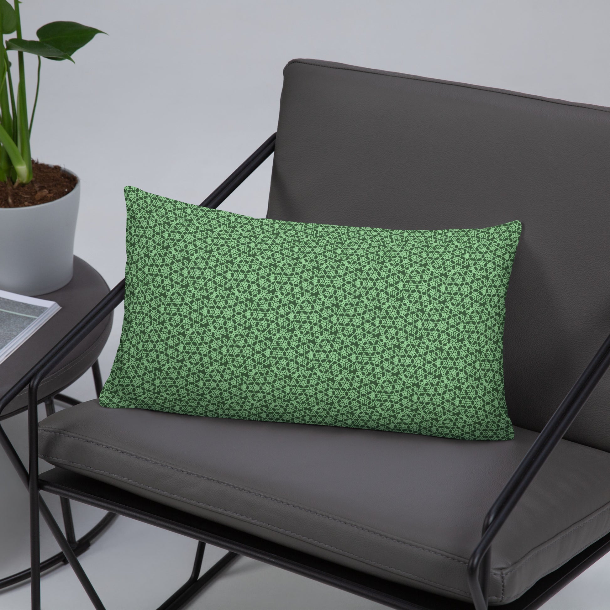 20″×12″ throw pillow with the 'Heptagon' green geometric pattern on a chair.