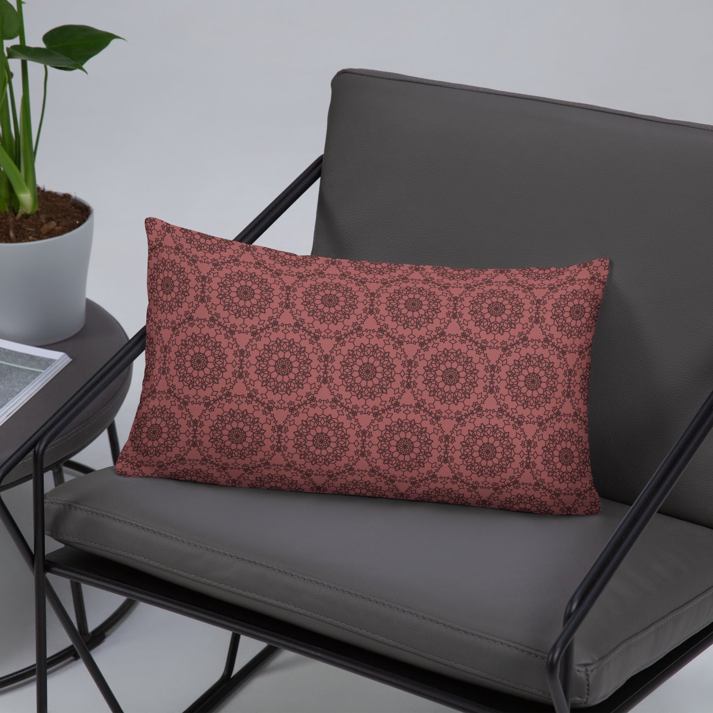20″×12″ throw pillow with the 'Dodecagon' rose geometric pattern on grey modern armchair.
