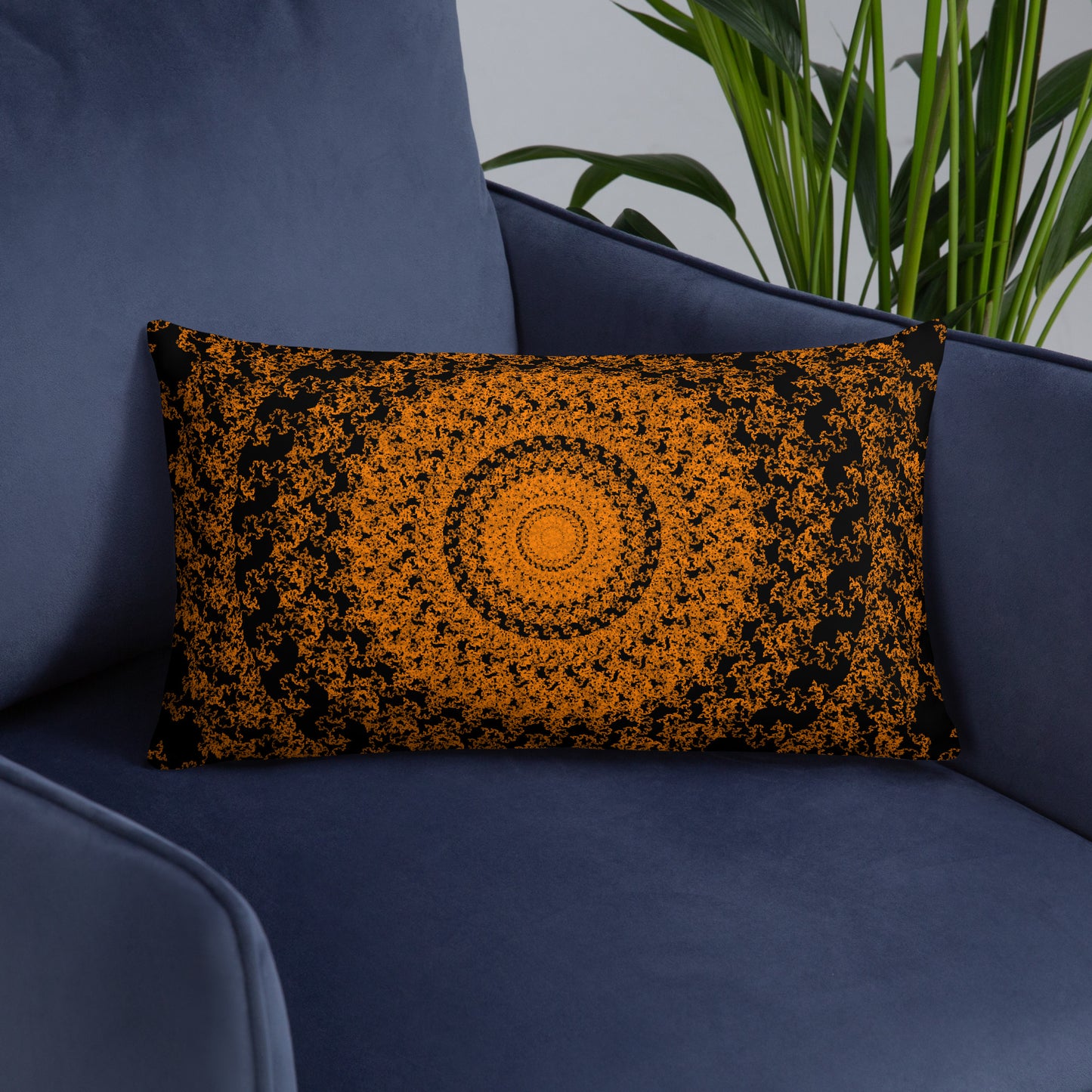 20″×12″ throw pillow with the 'The Sun' orange and black geometric design on an armchair.