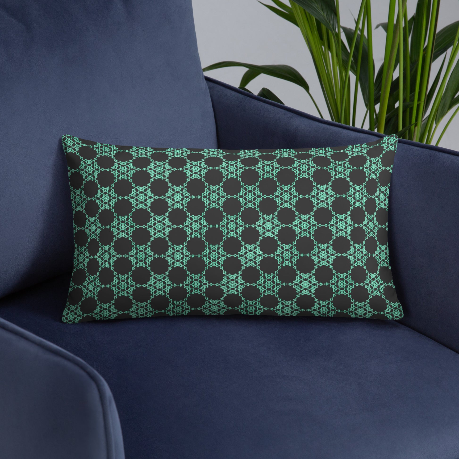 20″×12″ throw pillow with the 'Flowers Victory' charcoal and mint geometric pattern on an armchair.