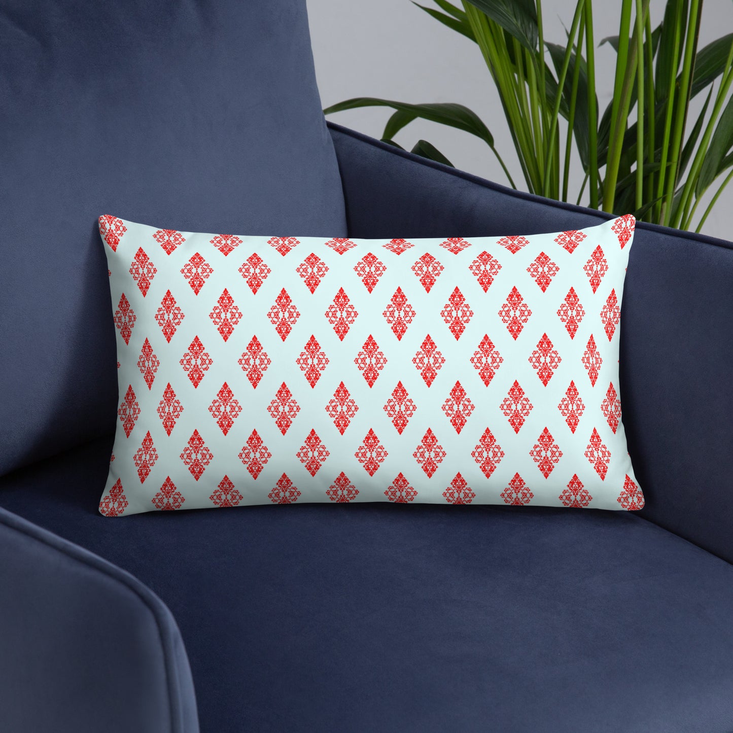 20″×12″ throw pillow with the 'Digon' sky blue and red geometric pattern on an armchair.