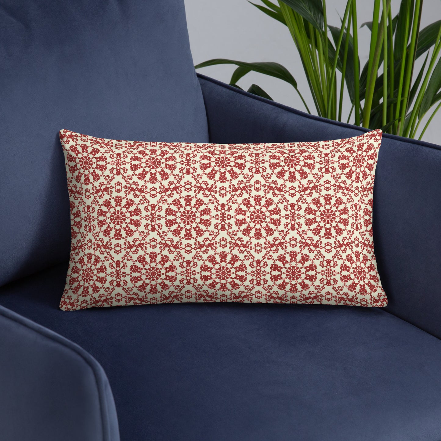 20″×12″ throw pillow with the ‘Decagon’ terracotta and beige geometric pattern on a navy blue armchair.