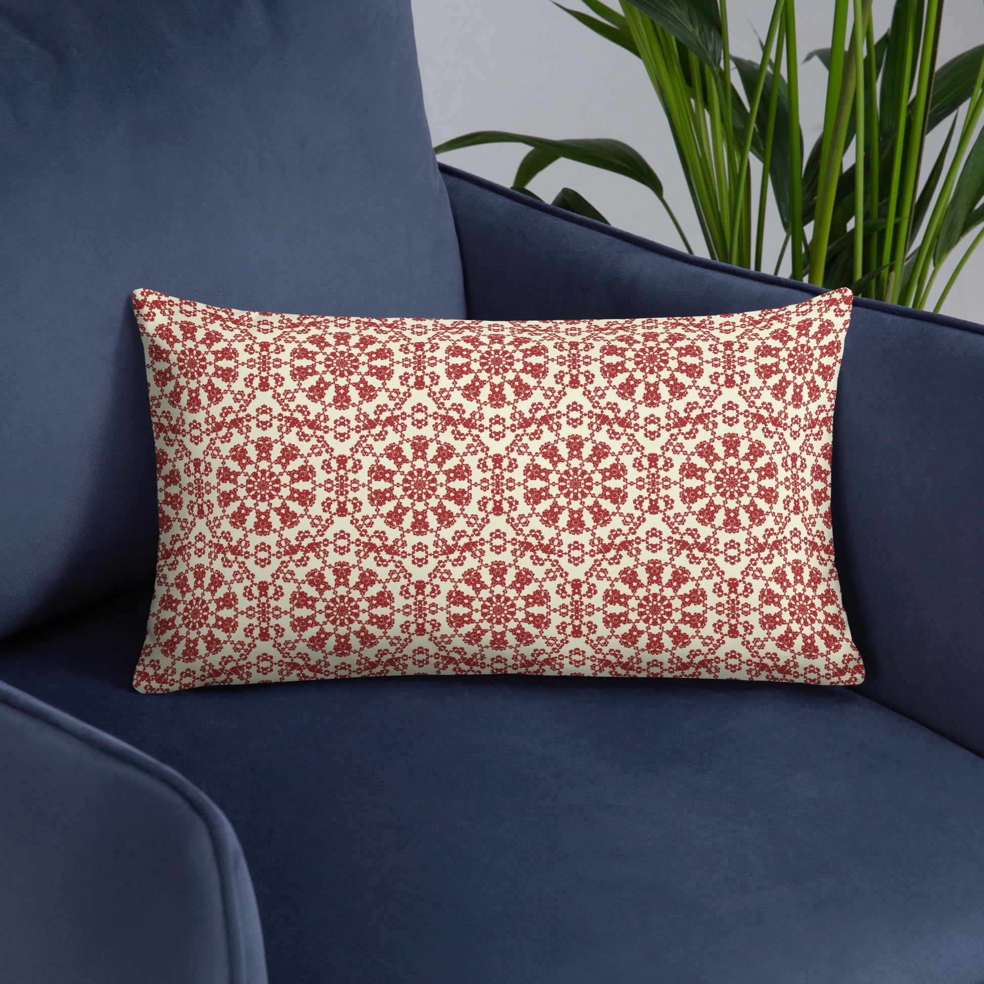 20″×12″ throw pillow with the ‘Decagon’ terracotta and beige geometric pattern on a navy blue armchair.