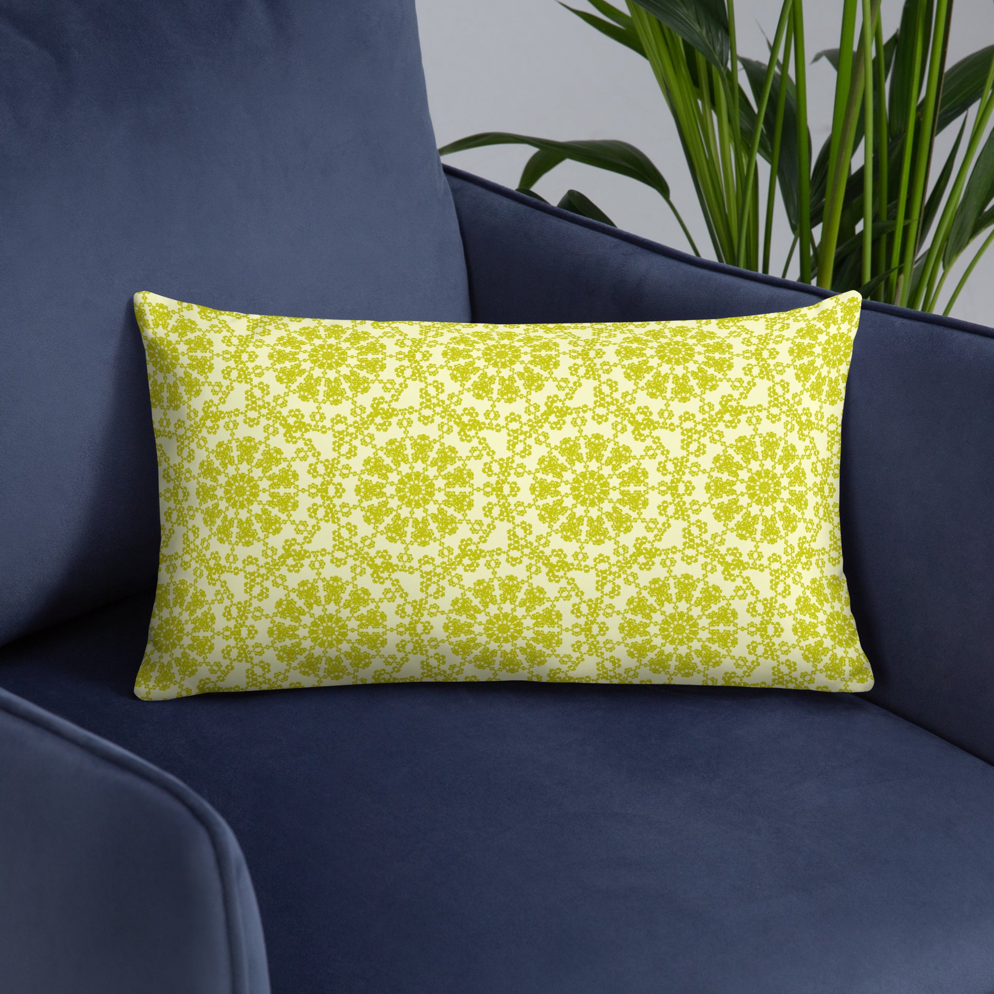 20″×12″ throw pillow with the 'Hendecagon' yellow-green geometric pattern on a navy armchair