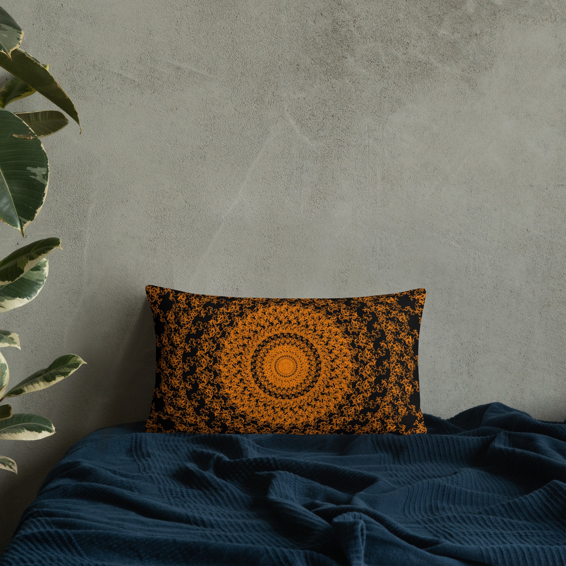 20″×12″ throw pillow with the 'The Sun' orange and black geometric design on a bed.