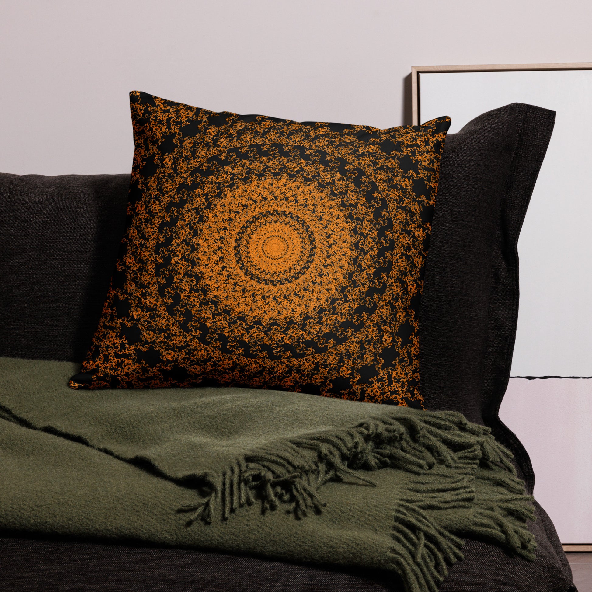 22″×22″ throw pillow with the 'The Sun' orange and black geometric design on a couch.