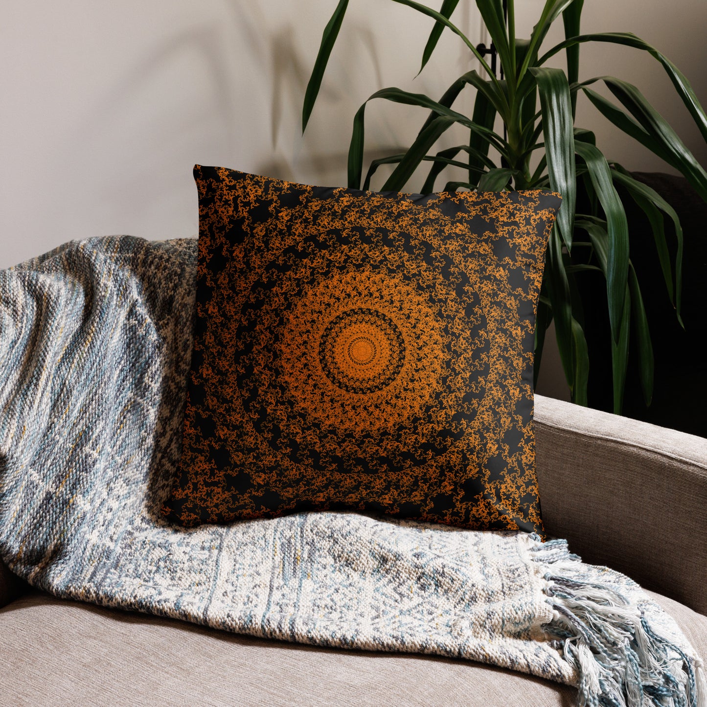 22″×22″ throw pillow with the 'The Sun' orange and black geometric design on a couch.