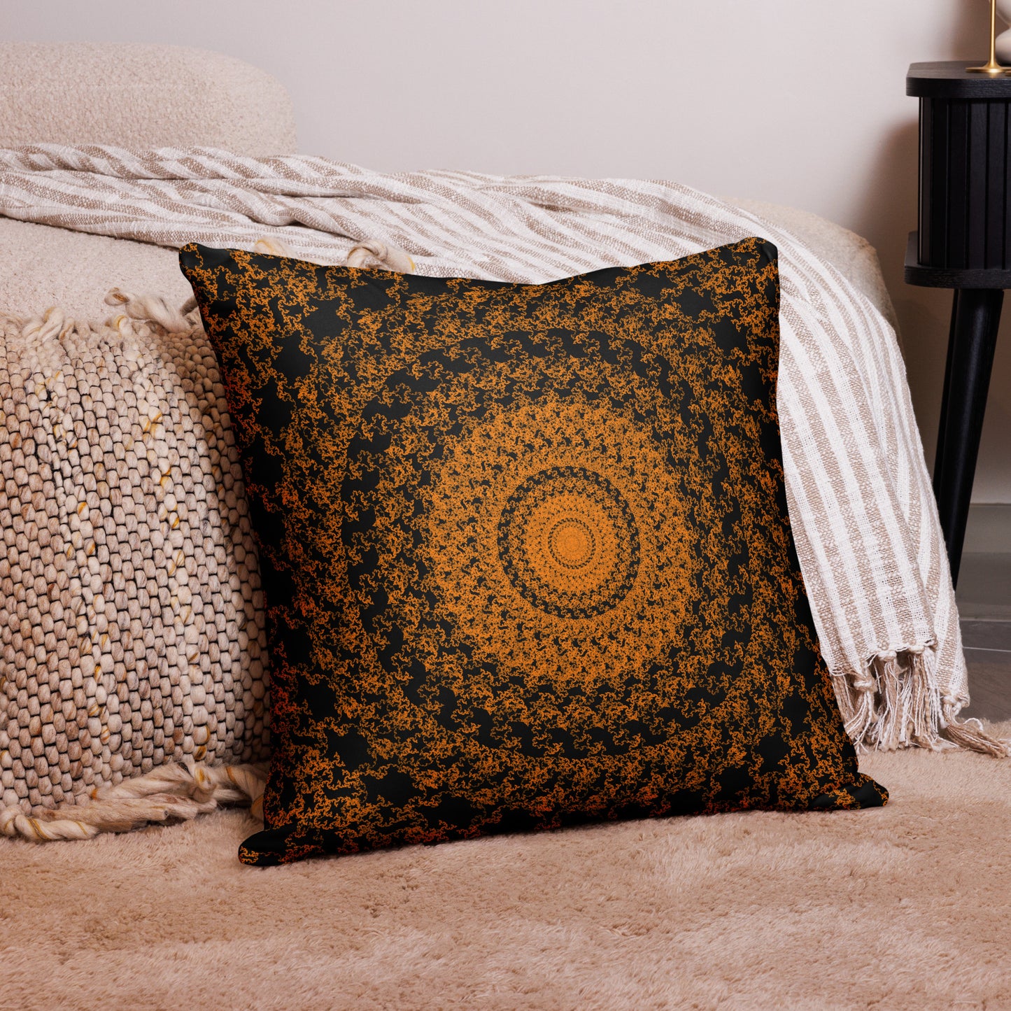 22″×22″ throw pillow with the 'The Sun' orange and black geometric design on a couch.